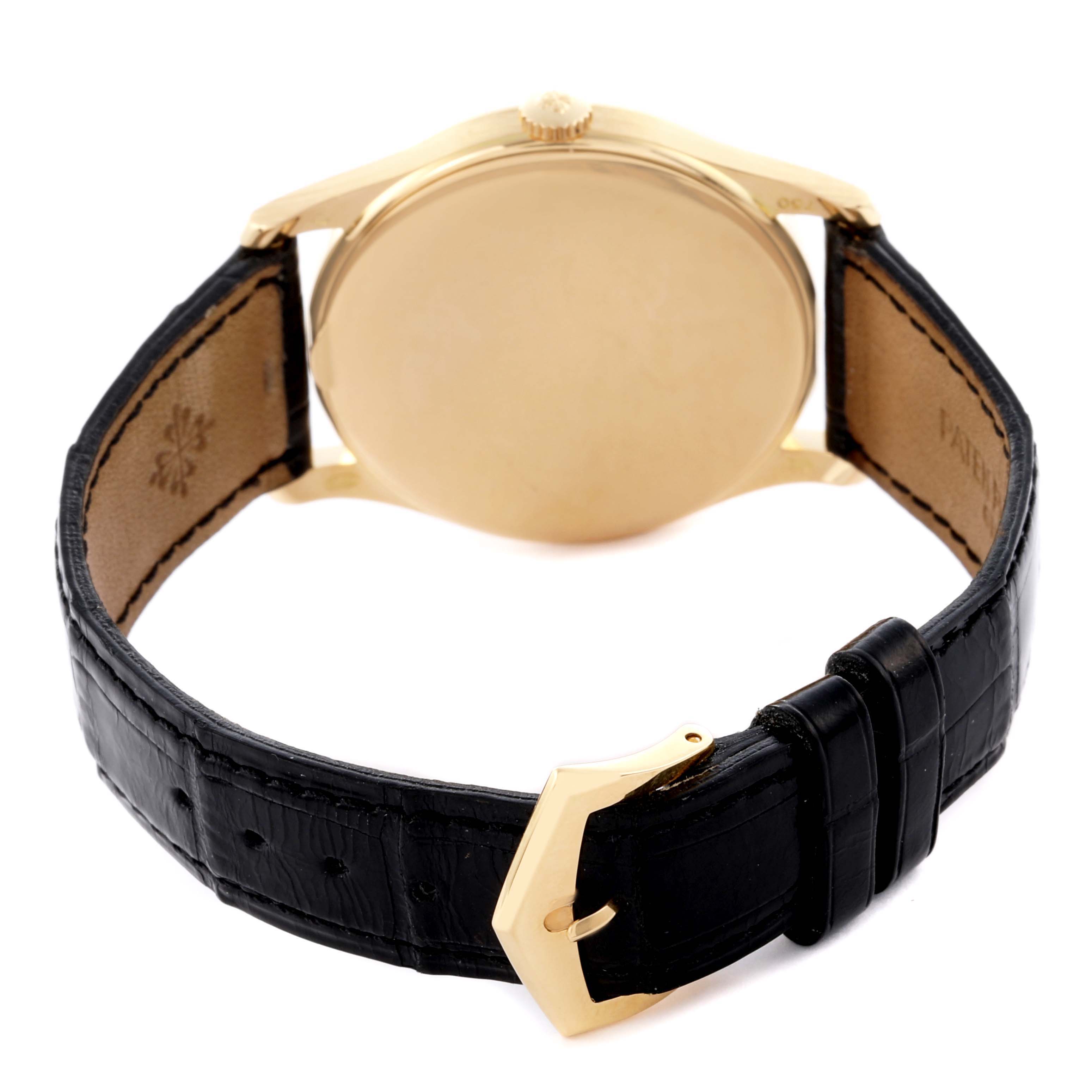 The Patek Philippe Calatrava 5196J Men's Yellow Gold Silver Dial 5196J Men's Yellow Gold Silver Dial watch is shown from the back angle, displaying the gold case and black leather strap.