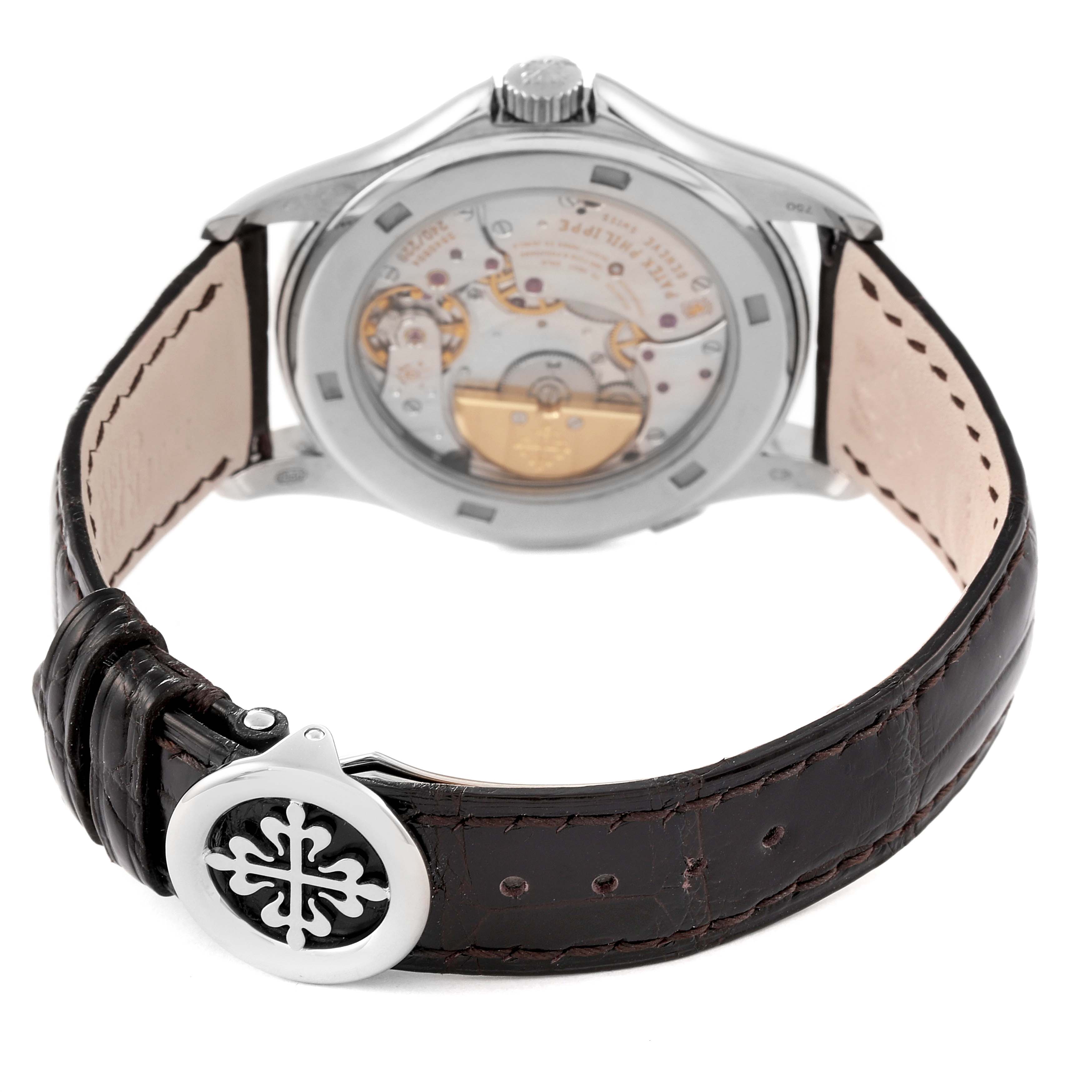 The image shows the back view of a Patek Philippe Complications 5130G Men's White Gold Silver Dial 5130G Men's White Gold Silver Dial watch, highlighting its movement and leather strap with clasp.