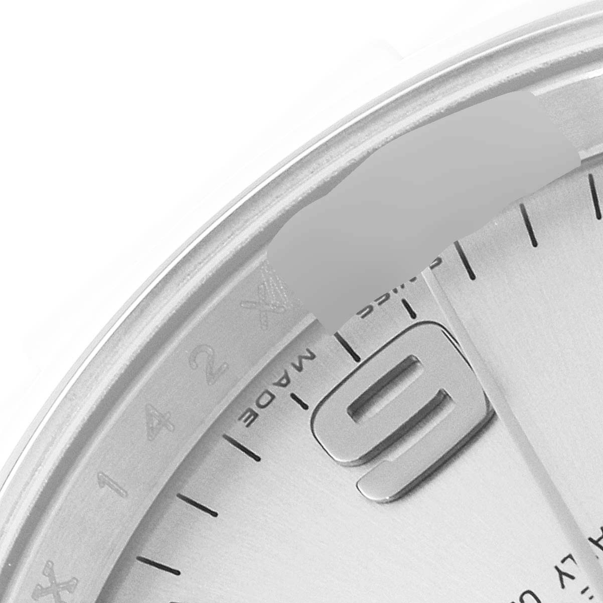 The image shows a close-up of the 9 o'clock marker and part of the bezel of the Rolex Air-King 114200 Men's Stainless Steel Silver Dial 114200 Men's Stainless Steel Silver Dial watch.