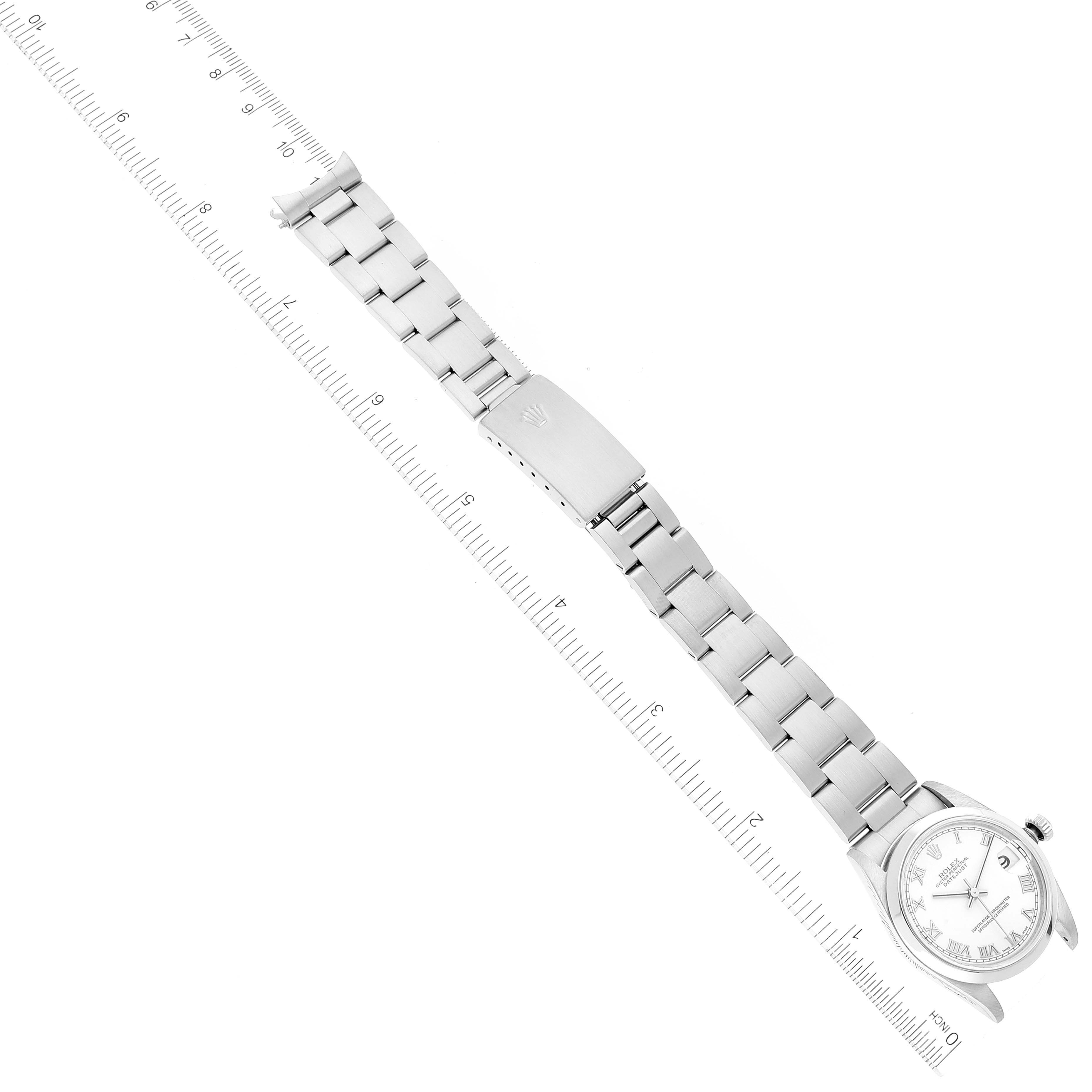 The image shows a Mid-Size Rolex watch laid flat with a focus on its bracelet, clasp, and face, measured against a ruler.