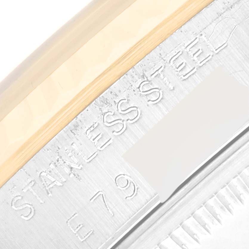 This close-up image shows the "STAINLESS STEEL" engraving and part of the serial number on the Rolex Datejust 16233 Men's Steel and Gold (two tone) Champagne Dial 16233 Men's Steel and Gold (two tone) Champagne Dial watch case.