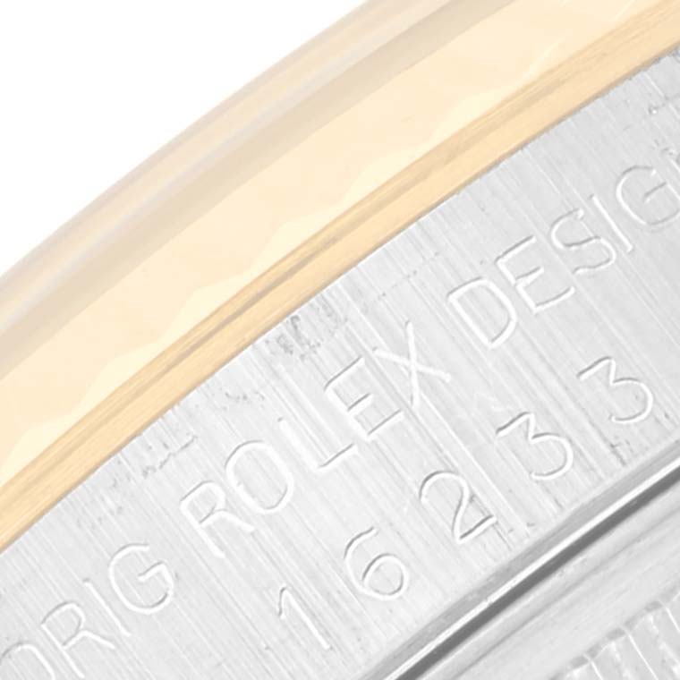 This image shows a close-up of the side of a Rolex Datejust 16233 Men's Steel and Gold (two tone) Champagne Dial 16233 Men's Steel and Gold (two tone) Champagne Dial watch, displaying part of the bezel and engraved writing on the case.