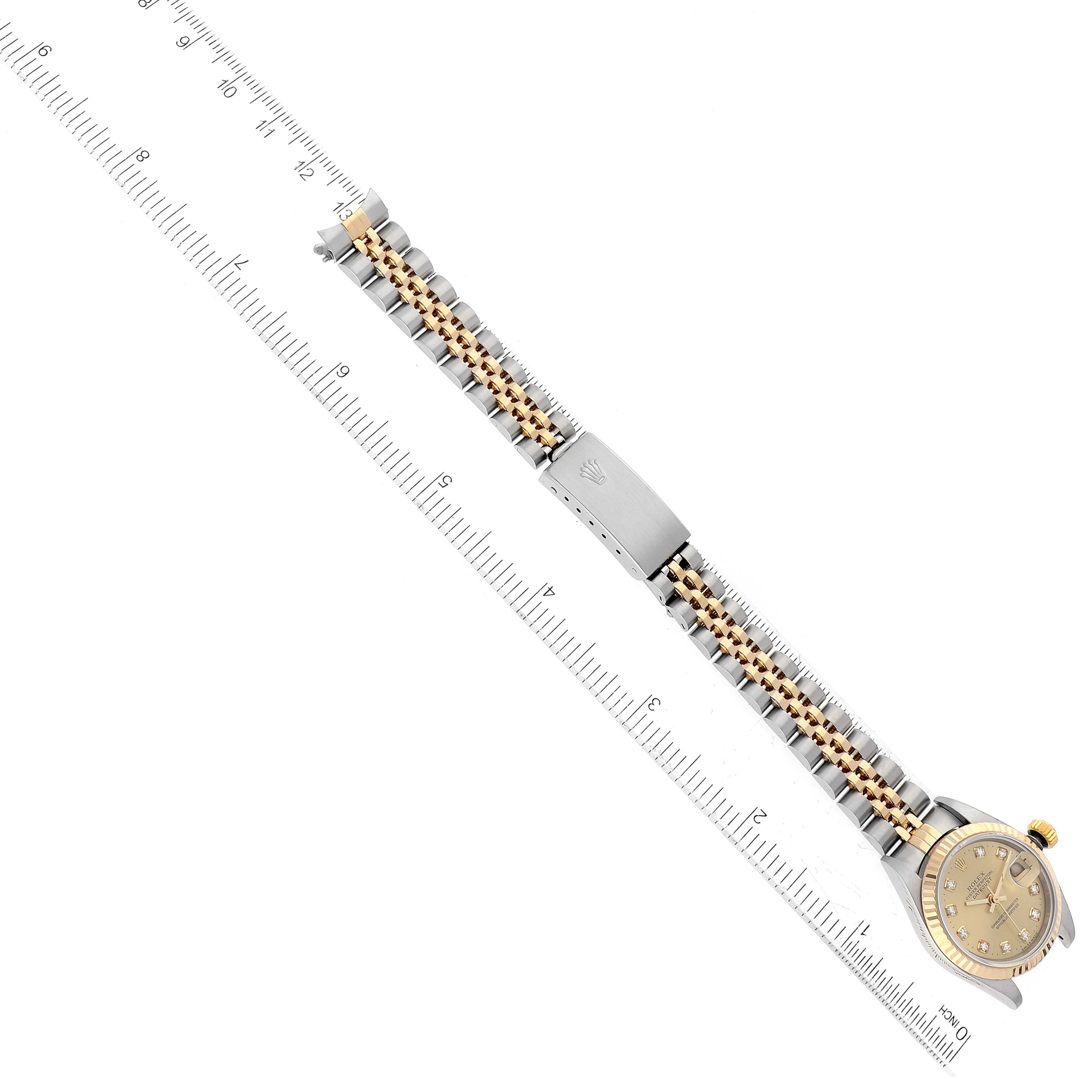 This image shows an overhead view of a Rolex Datejust 79173 Women's Steel and Gold (two tone) Champagne Dial 79173 Women's Steel and Gold (two tone) Champagne Dial watch displaying the bracelet, clasp, and part of the dial with a ruler beside it.