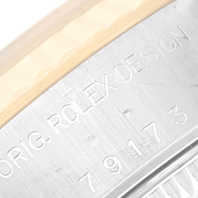 This is a close-up angle showing the engraved casing of a Rolex Datejust 79173 Women's Steel and Gold (two tone) Champagne Dial 79173 Women's Steel and Gold (two tone) Champagne Dial watch.