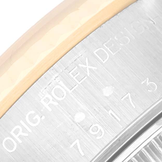 This image shows a close-up of the side of a Rolex Datejust 79173 Women's Steel and Gold (two tone) White Dial 79173 Women's Steel and Gold (two tone) White Dial watch case, highlighting the engraved model number and part of the bezel.