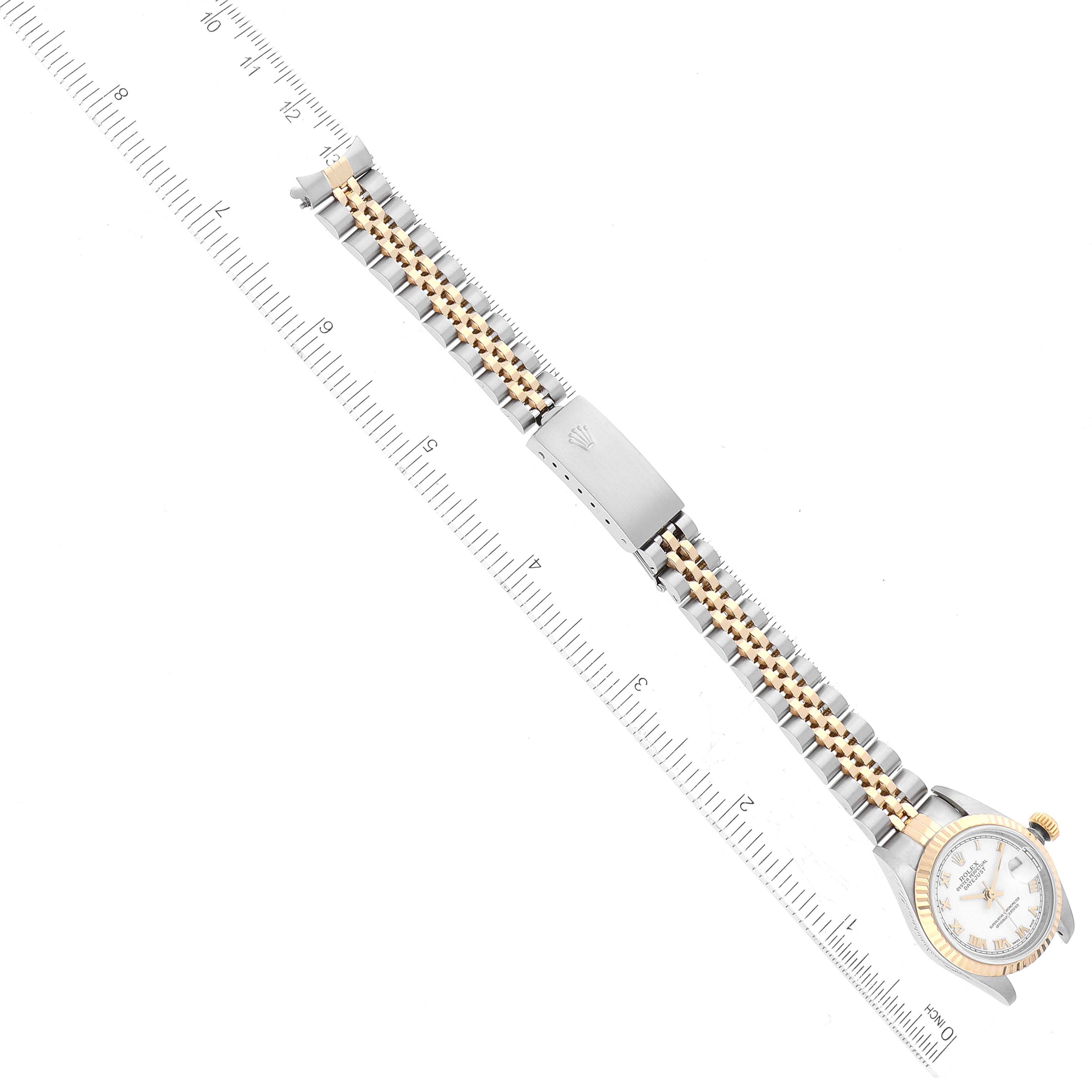 This image shows the top view of a Rolex Datejust 79173 Women's Steel and Gold (two tone) White Dial 79173 Women's Steel and Gold (two tone) White Dial watch, including its face, band, and clasp, alongside a measuring ruler.