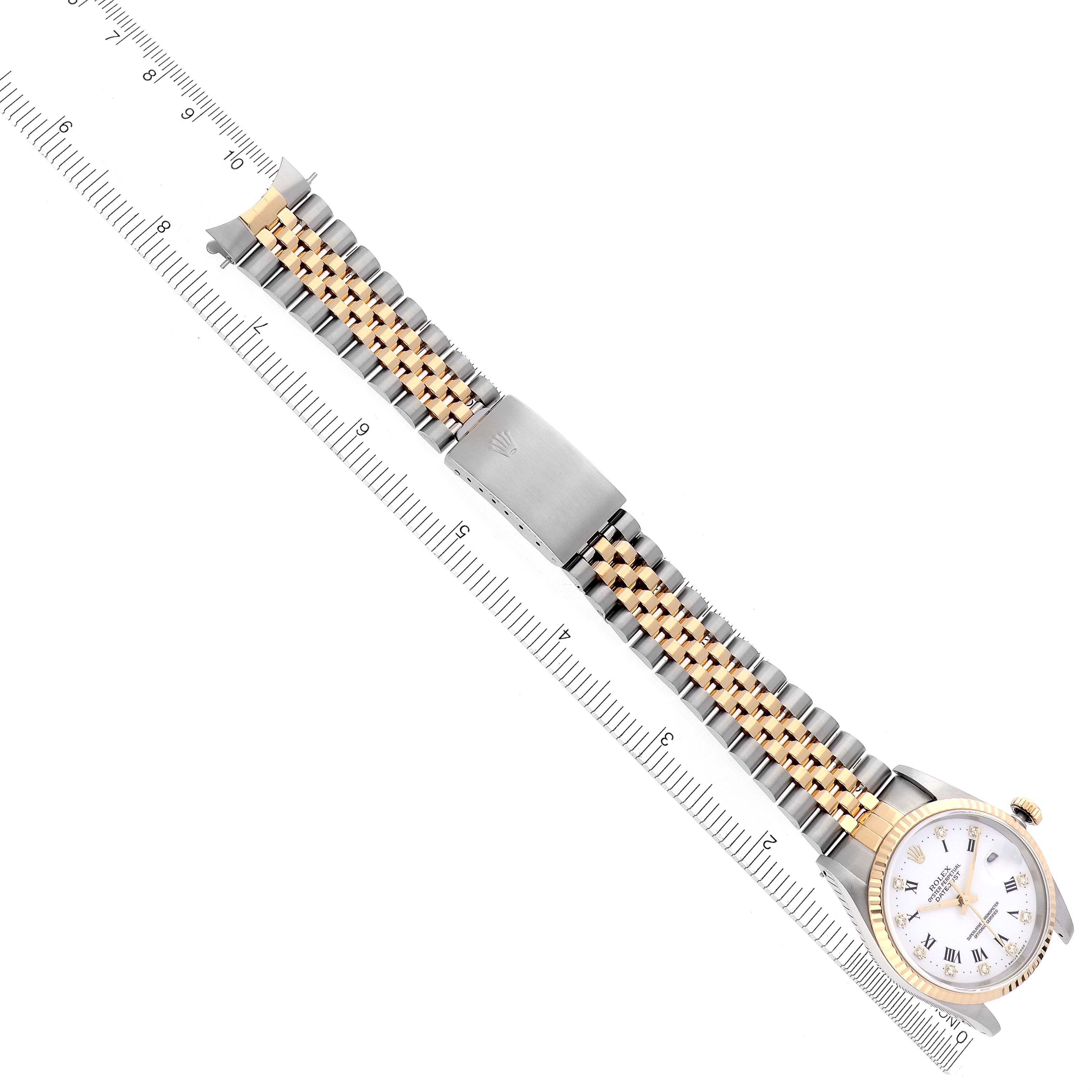 The Rolex Datejust 16233 Men's Steel and Gold (two tone) White Dial 16233 Men's Steel and Gold (two tone) White Dial watch is shown from a top-down angle, displaying the face, bracelet, and clasp alongside a measurement ruler.