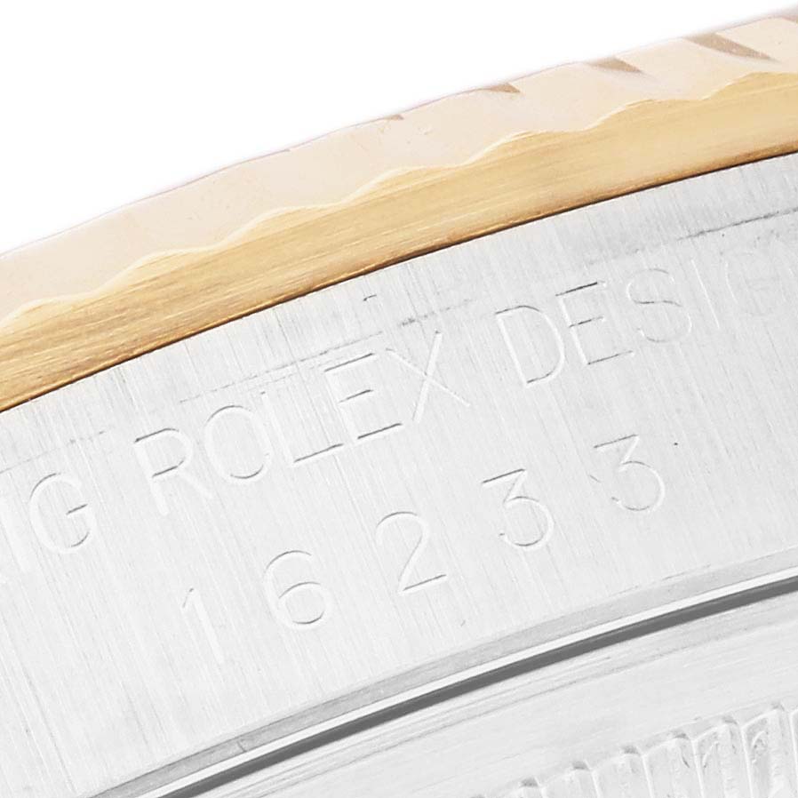 The image shows a close-up of the Rolex Datejust 16233 Men's Steel and Gold (two tone) White Dial 16233 Men's Steel and Gold (two tone) White Dial model's bezel and engraved case edge, featuring a fluted design.