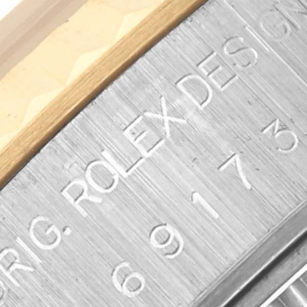 The image shows a close-up of the Rolex Datejust 69173 Women's Steel and Gold (two tone) White Dial 69173 Women's Steel and Gold (two tone) White Dial bezel, highlighting "ROLEX DESIGN" and part of a serial number.