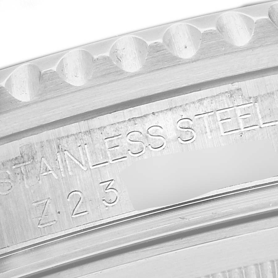 This close-up image shows the stainless steel bezel and engravings on the case of a Rolex GMT-Master 16710 Men's Stainless Steel Black Dial 16710 Men's Stainless Steel Black Dial watch.