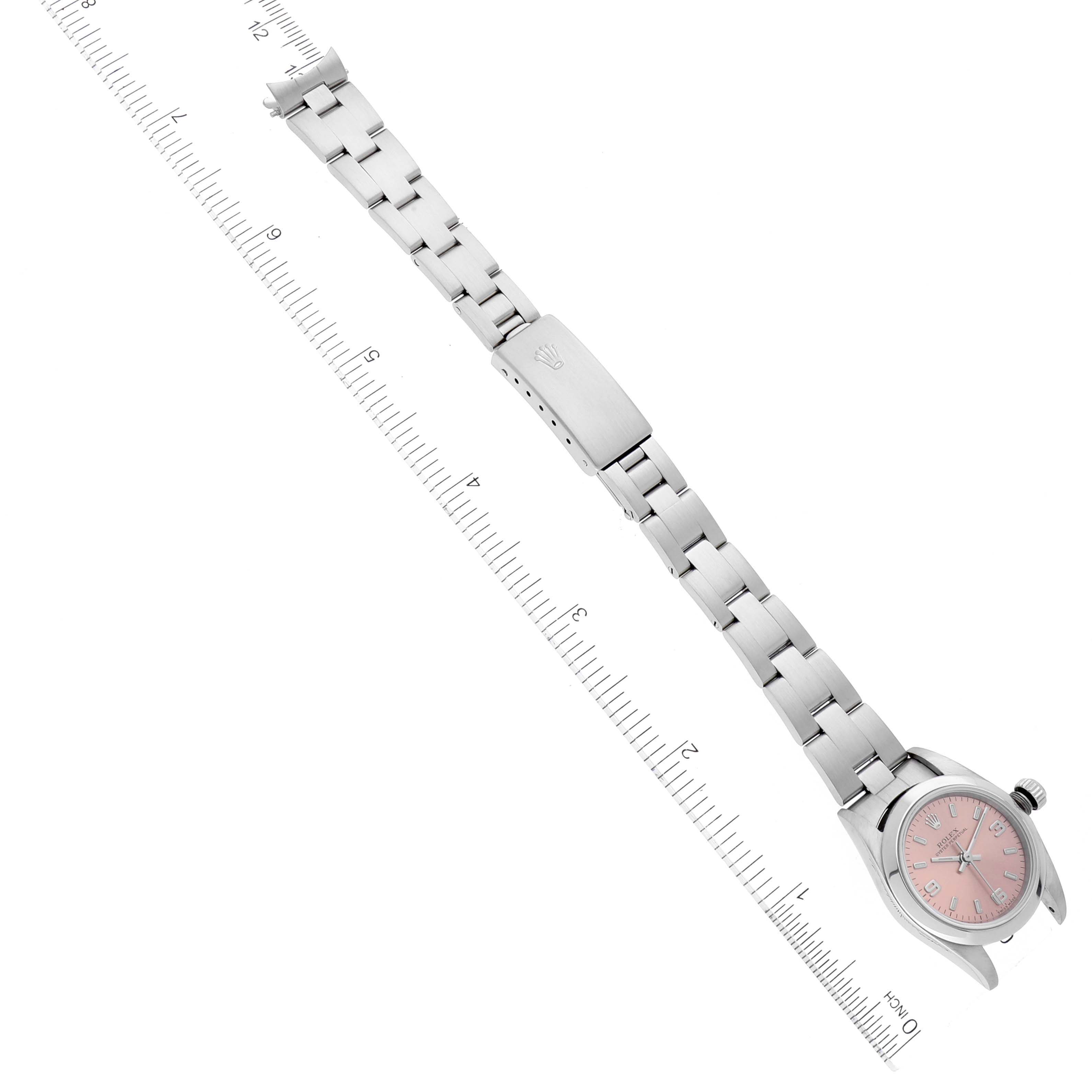 The image shows a top-down view of a Rolex Oyster Perpetual 76080 Women
s Stainless Steel Pink Dial 76080 Women
s Stainless Steel Pink Dial watch with a pink dial and fully extended metal bracelet.