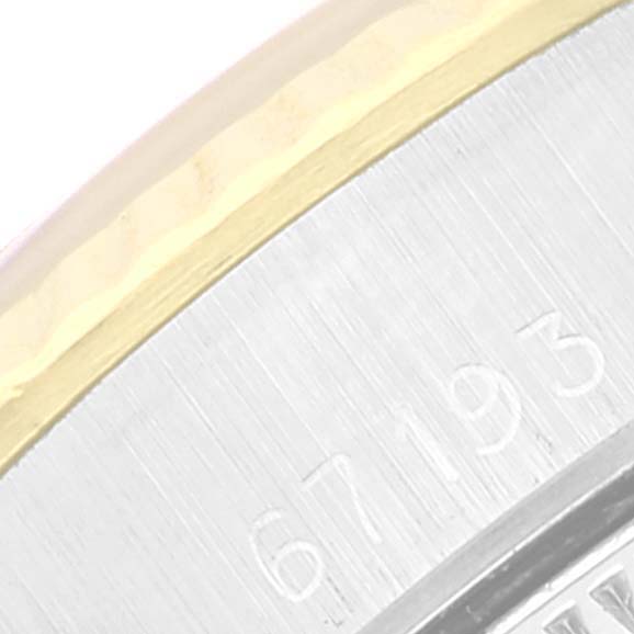 This is a close-up image of the edge and serial number of a Rolex Oyster Perpetual 67193 Women
s Steel and Gold (two tone) Champagne Dial 67193 Women
s Steel and Gold (two tone) Champagne Dial watch.