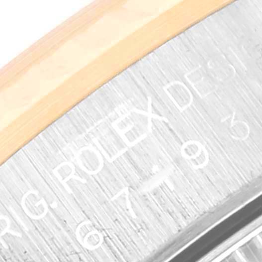 This close-up image of the Rolex Oyster Perpetual 67193 Women's Steel and Gold (two tone) Champagne Dial 67193 Women's Steel and Gold (two tone) Champagne Dial watch shows the engraved inner bezel with the "Rolex" branding.