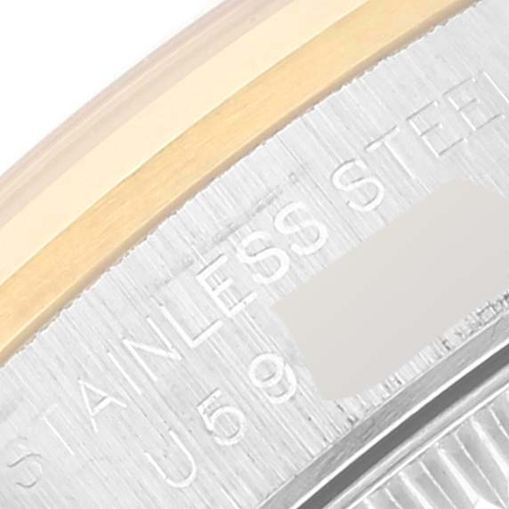 The image shows a close-up of the side of a Rolex Oyster Perpetual 67183 Women's Steel and Gold (two tone) Grey Dial 67183 Women's Steel and Gold (two tone) Grey Dial model watch, focusing on the stainless steel and gold parts with engraved text.
