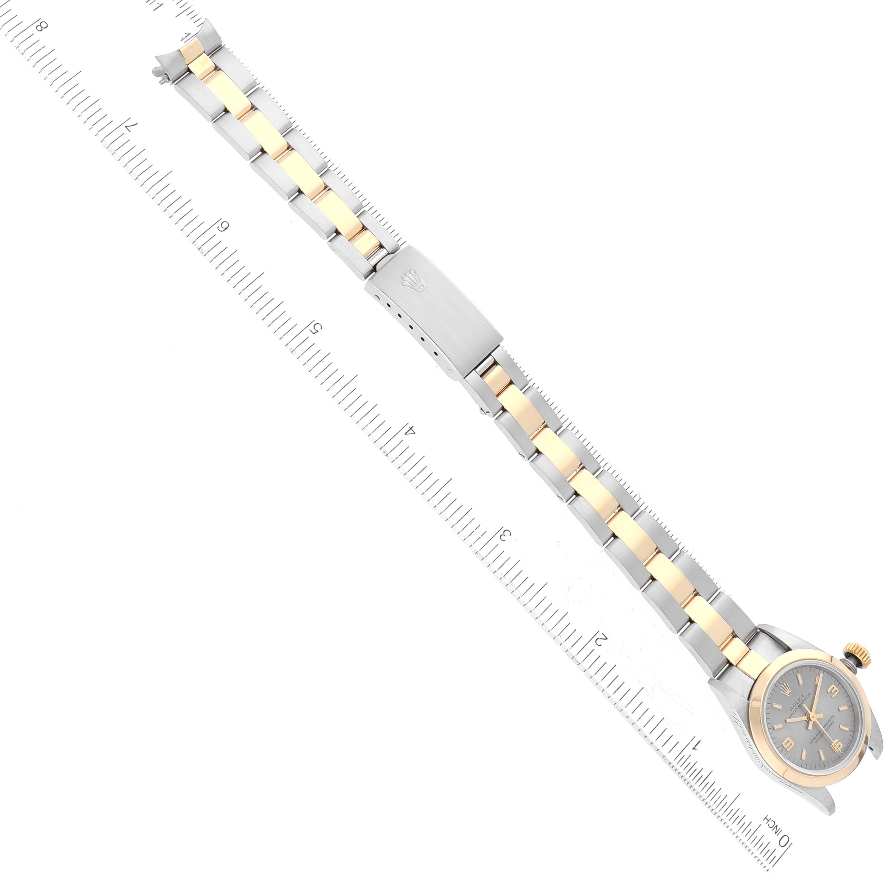 The Rolex Oyster Perpetual 67183 Women's Steel and Gold (two tone) Grey Dial 67183 Women's Steel and Gold (two tone) Grey Dial watch is shown fully extended with its bracelet aligned next to a ruler for measurement.