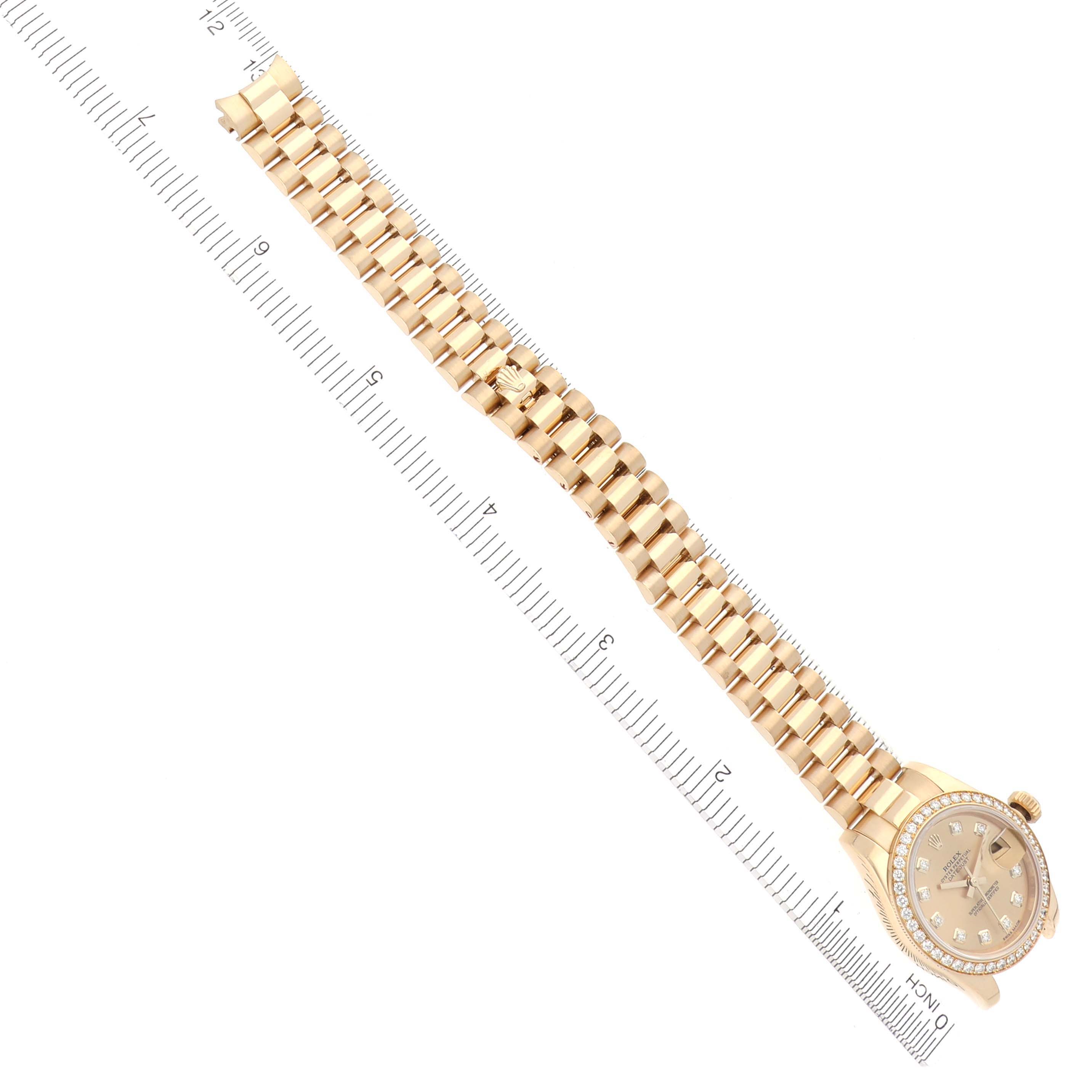 The Rolex President 179138 Women's Yellow Gold Champagne Dial 179138 Women's Yellow Gold Champagne Dial watch is shown from a top-down angle, displaying the face and the full gold bracelet aligned with a measuring ruler.