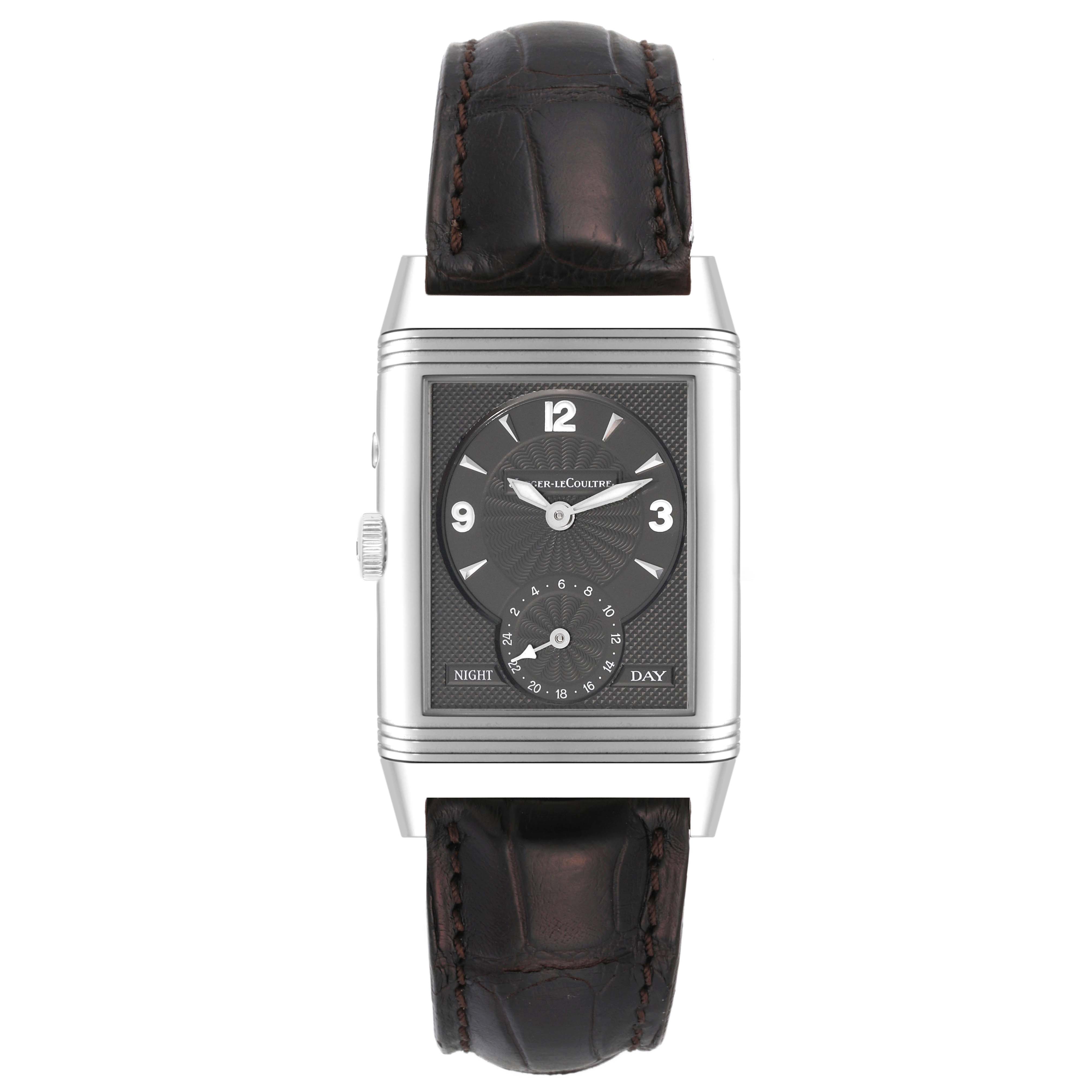 The image shows a frontal view of a Jaeger-LeCoultre Reverso watch with a leather strap and a rectangular face displaying time, day, and night indicators.