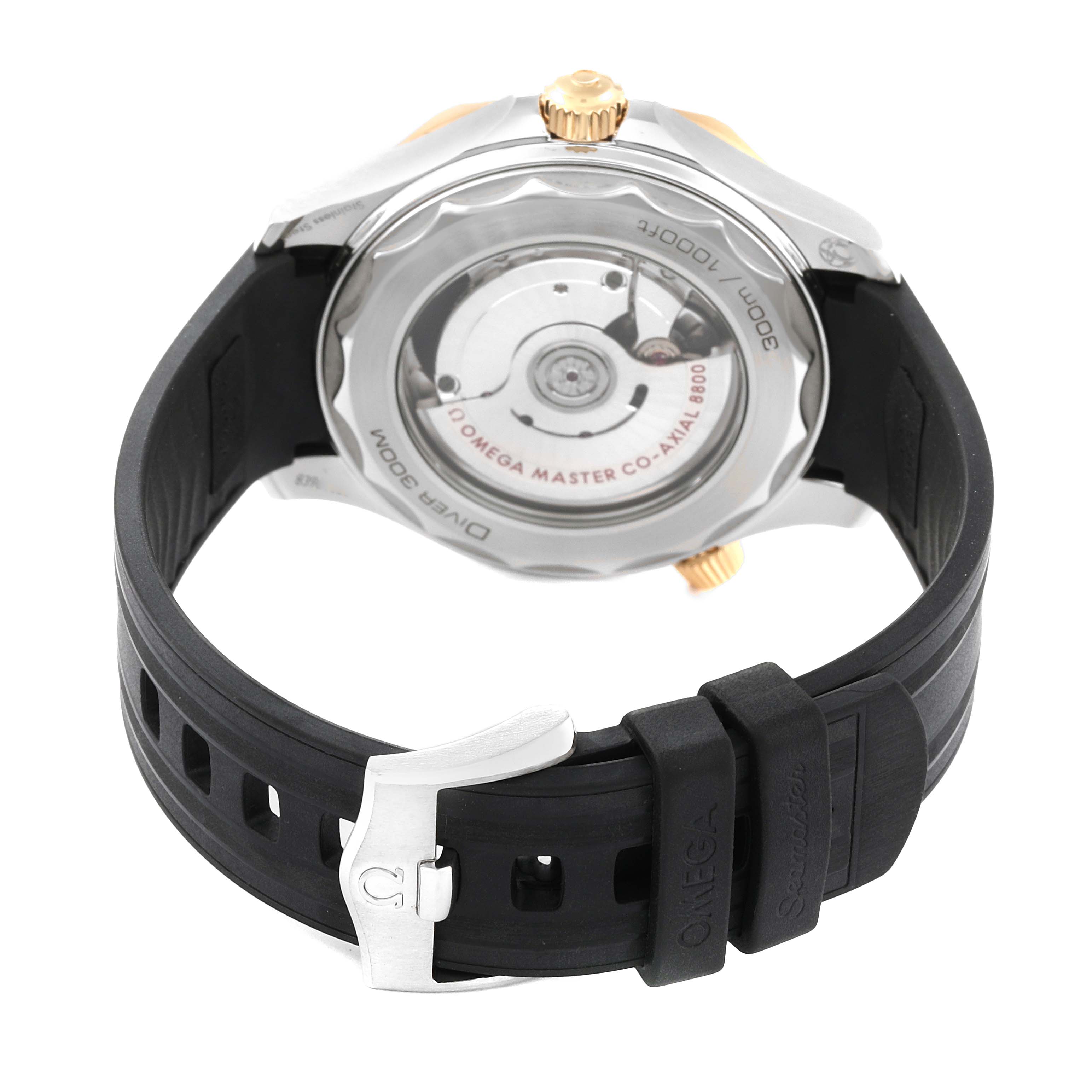 The image shows the back view of an Omega Seamaster 210.22.42.20.01.001 Men's Steel and Gold (two tone) Black Dial 210.22.42.20.01.001 Men's Steel and Gold (two tone) Black Dial watch, featuring the movement and a black rubber strap with a clasp.