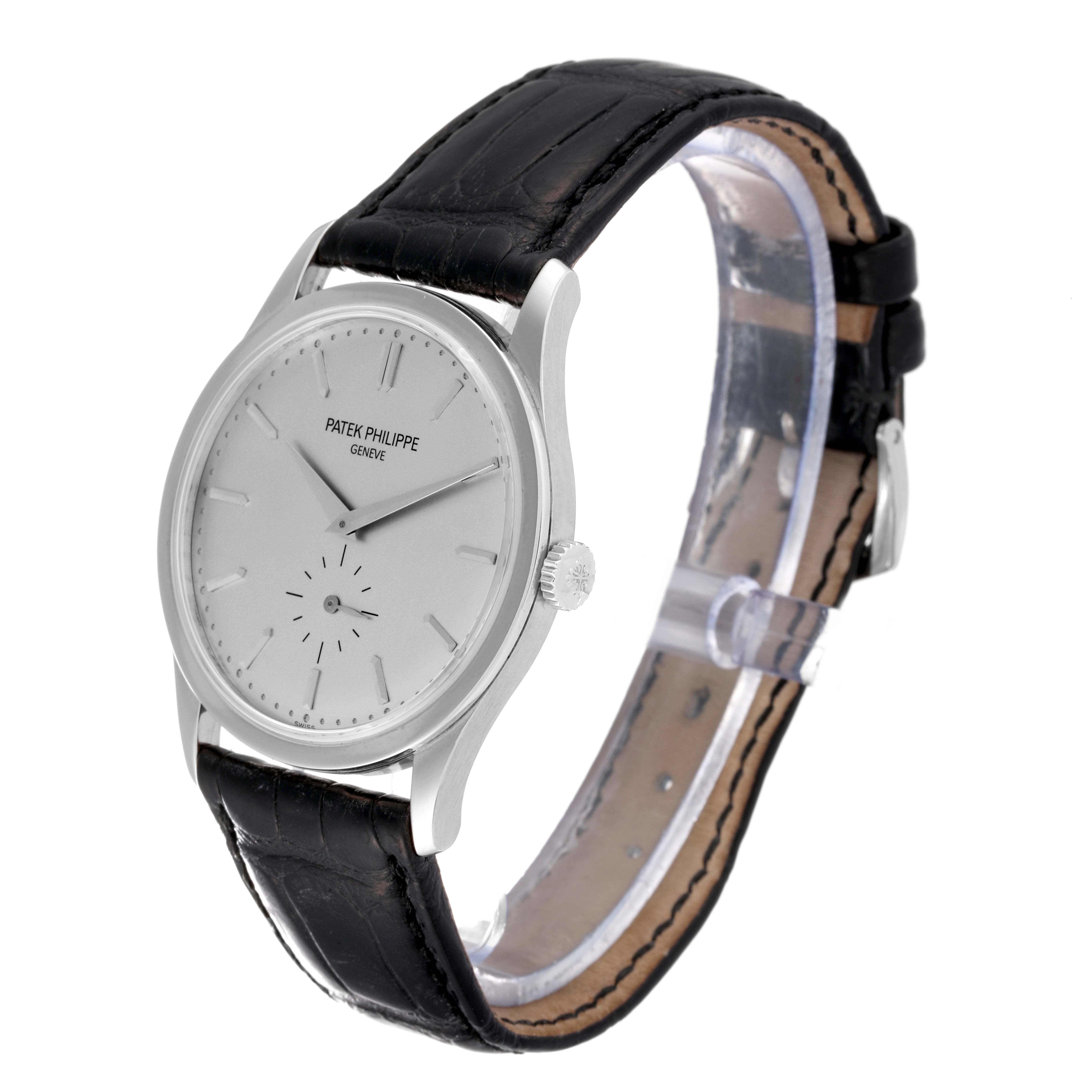 The image shows a Patek Philippe Calatrava 5196G Men
s White Gold Silver Dial 5196G Men
s White Gold Silver Dial watch at an oblique angle, highlighting the watch face, crown, case, and leather strap.