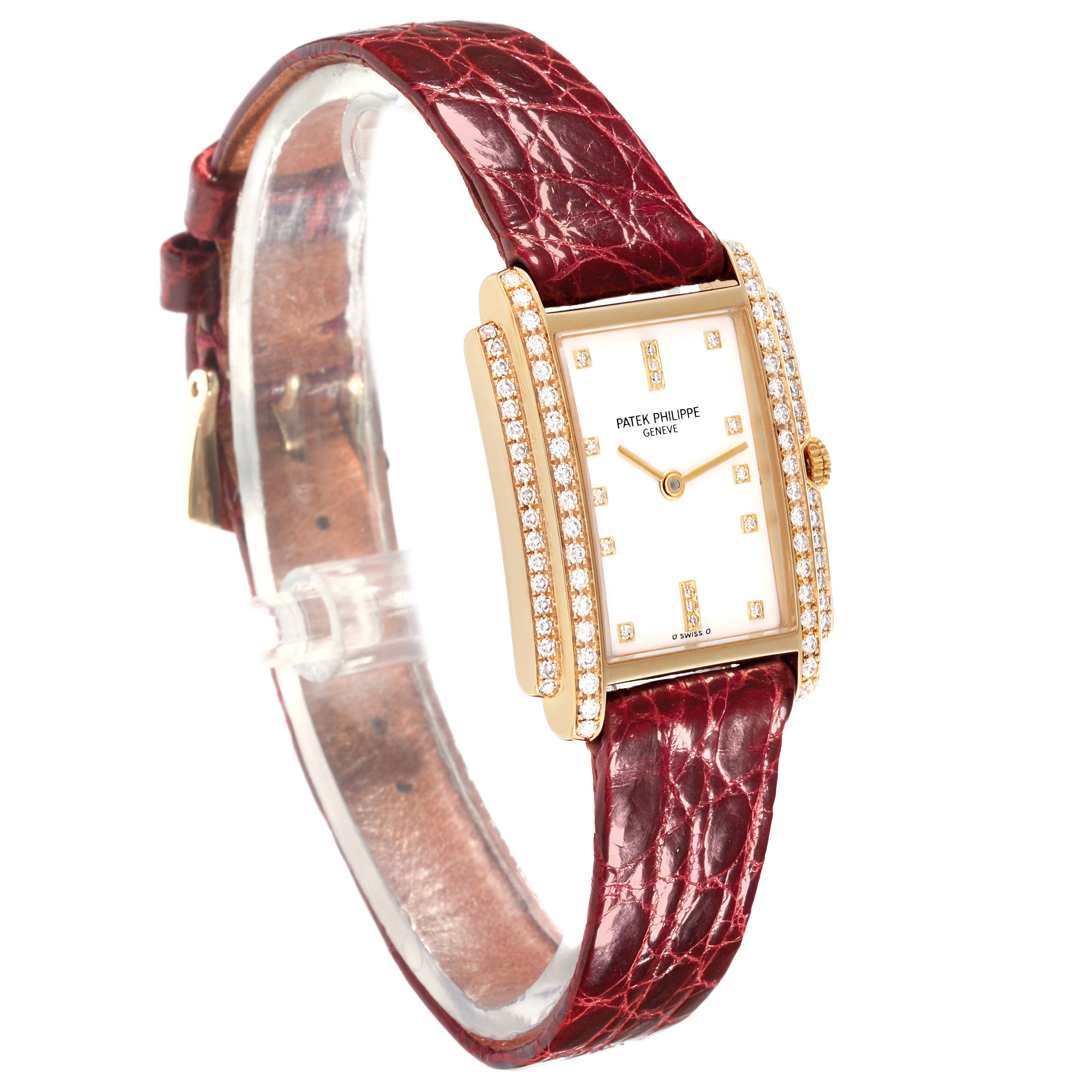 The Patek Philippe Gondolo 4825/101J Women's Yellow Gold White Dial 4825/101J Women's Yellow Gold White Dial watch is shown from a side angle, highlighting the diamond-encrusted bezel and red leather strap.