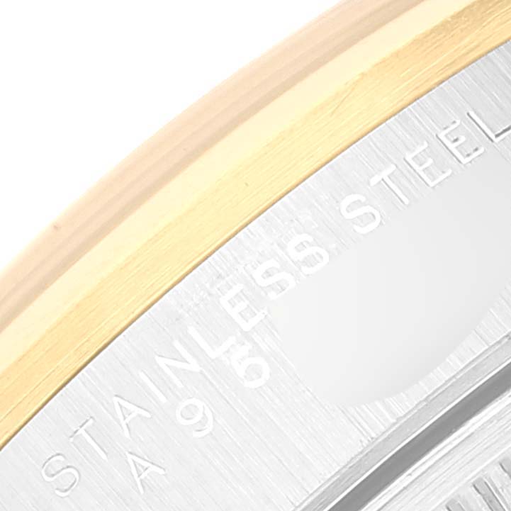 The image shows a close-up of the bezel and a portion of the case back of a Rolex Date 15203 Men's Steel and Gold (two tone) Blue Dial 15203 Men's Steel and Gold (two tone) Blue Dial model watch, highlighting the "STAINLESS STEEL" engraving.