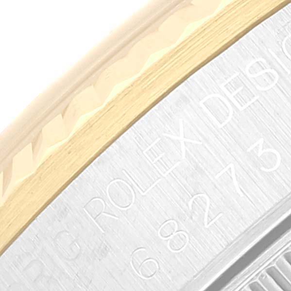 This image shows a close-up of the side of a Rolex Mid-Size 68273 Women's Steel and Gold (two tone) Beige Dial 68273 Women's Steel and Gold (two tone) Beige Dial watch case, displaying the engraved model number and part of the bezel.