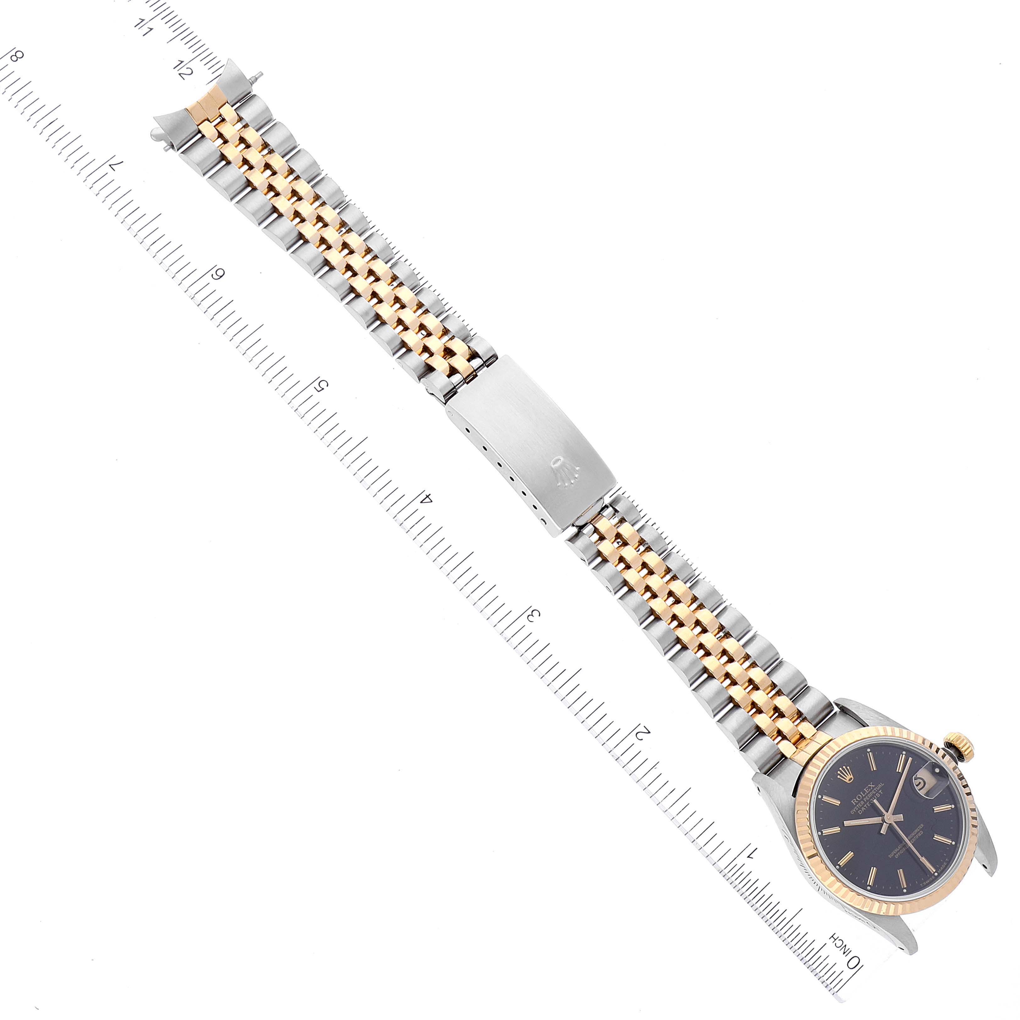 The image shows a top-down view of a Rolex Mid-Size 68273 Women
s Steel and Gold (two tone) Black Dial 68273 Women
s Steel and Gold (two tone) Black Dial watch displaying the bracelet, clasp, and part of the face.