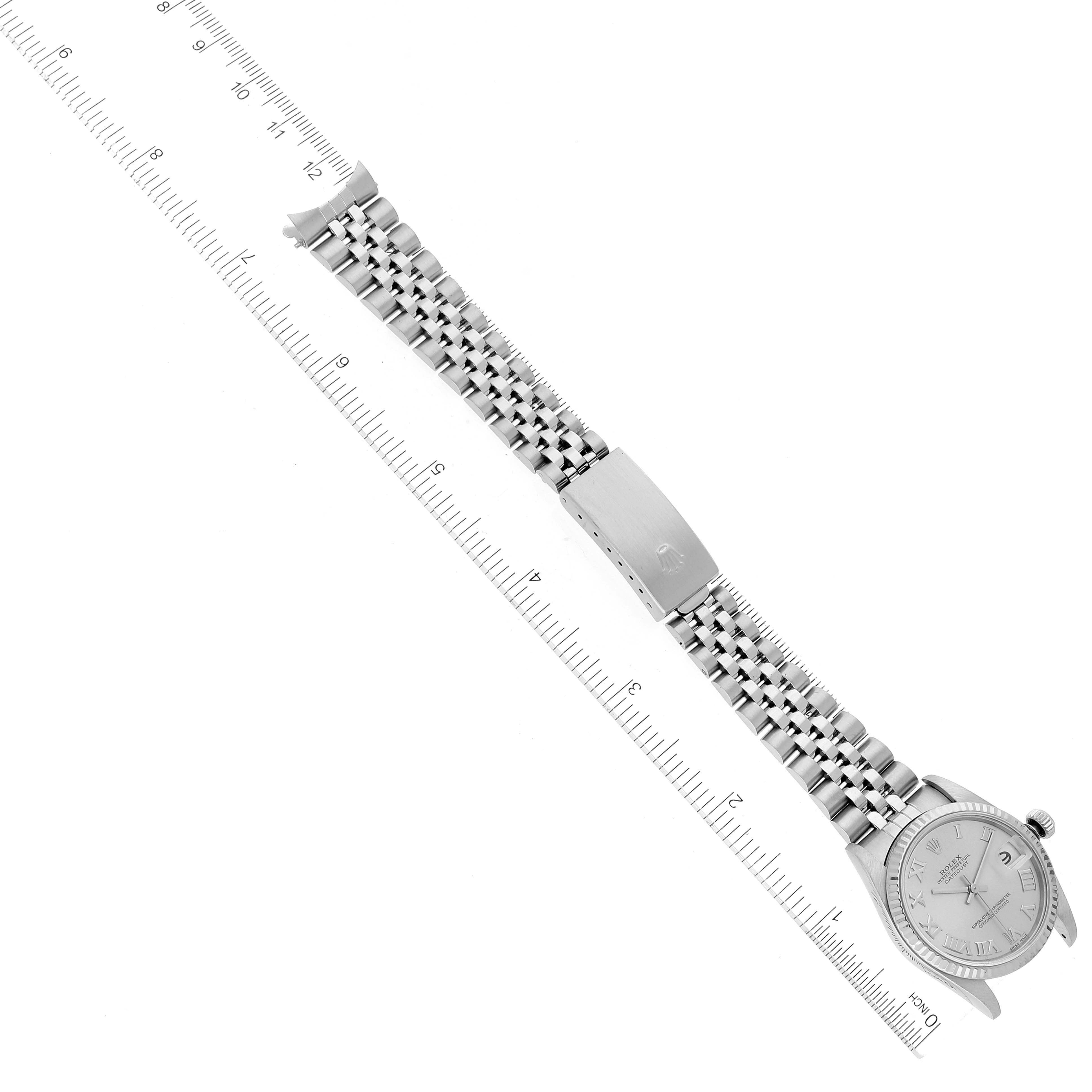The image shows a Rolex Mid-Size 78274 Women
s Stainless Steel Silver Dial 78274 Women
s Stainless Steel Silver Dial watch laid flat, displaying the entire bracelet, clasp, and face, aligned with rulers for measurement.