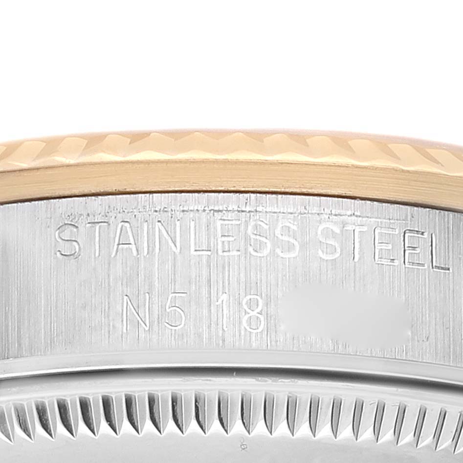 This image shows a close-up view of the bezel and part of the case on a Mid-Size Rolex watch, highlighting the "STAINLESS STEEL" engraving.