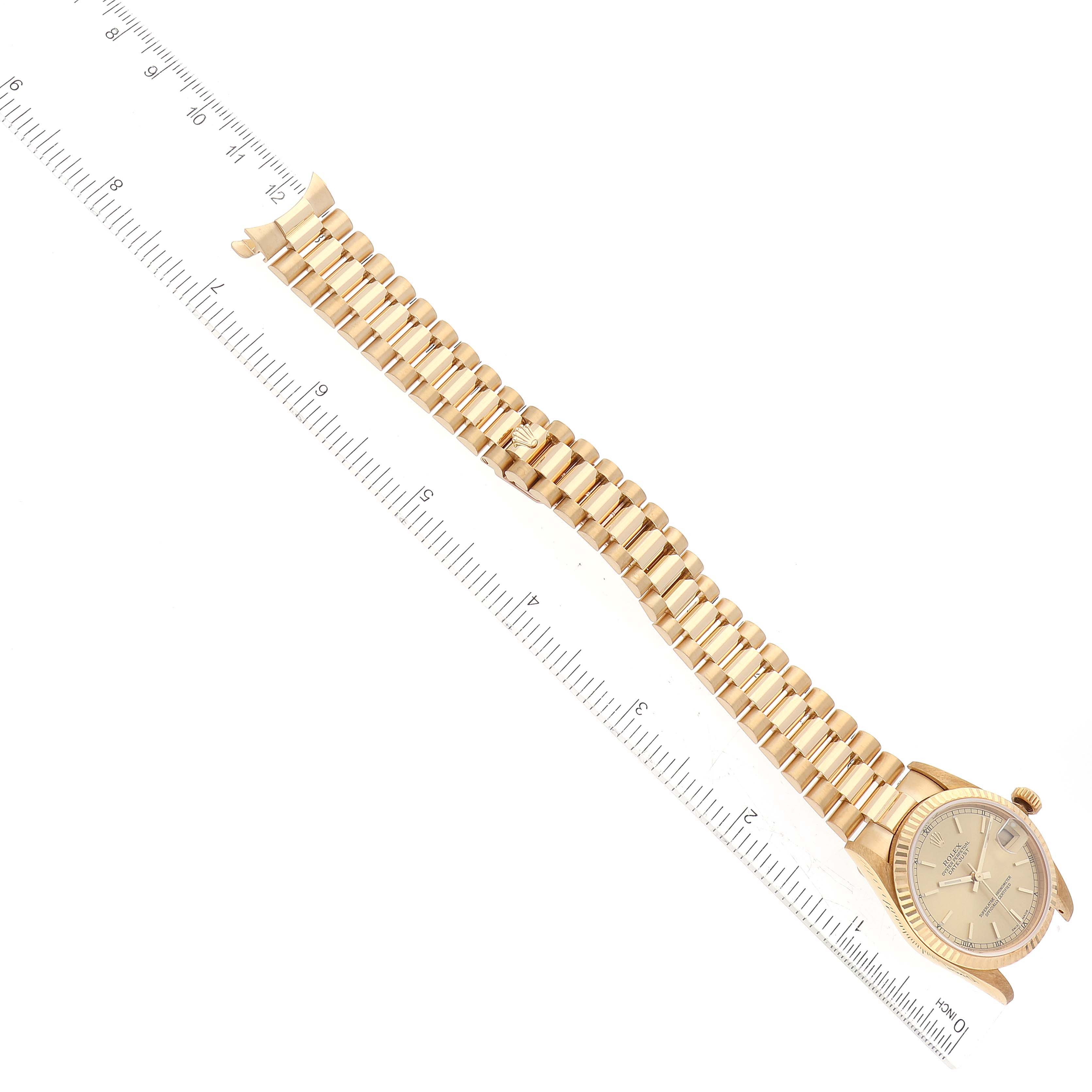 The image shows a top-down view of a Rolex President 78278 Women's Yellow Gold Champagne Dial 78278 Women's Yellow Gold Champagne Dial model watch with a gold bracelet and ruler for scale.