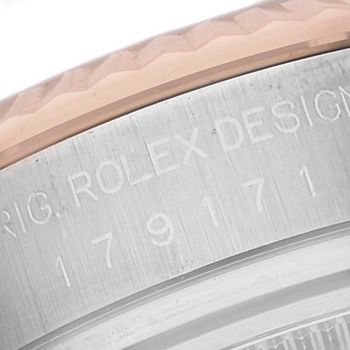 The image shows a close-up of the engraved serial number and part of the fluted bezel on a Rolex Datejust 179171 Women's Steel and Gold (two tone) Silver Dial 179171 Women's Steel and Gold (two tone) Silver Dial watch.