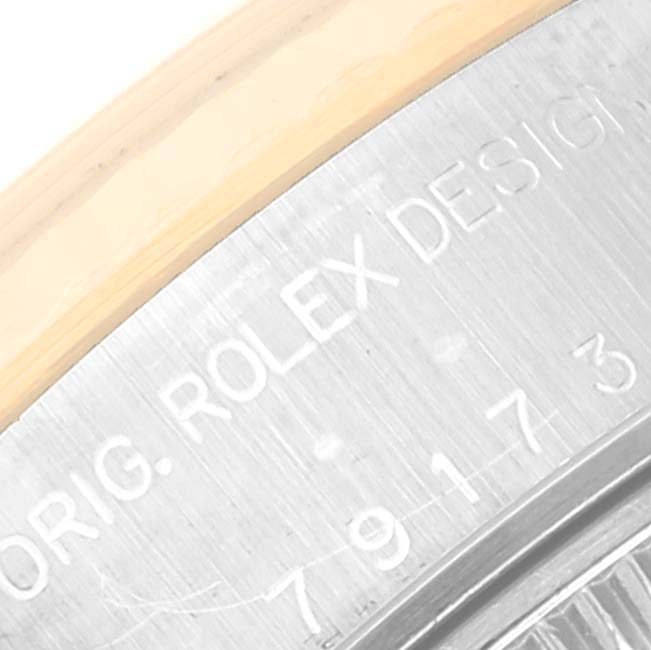This close-up image shows the side view of a Rolex Datejust 79173 Women's Steel and Gold (two tone) Champagne Dial 79173 Women's Steel and Gold (two tone) Champagne Dial watch's case with engraved details.