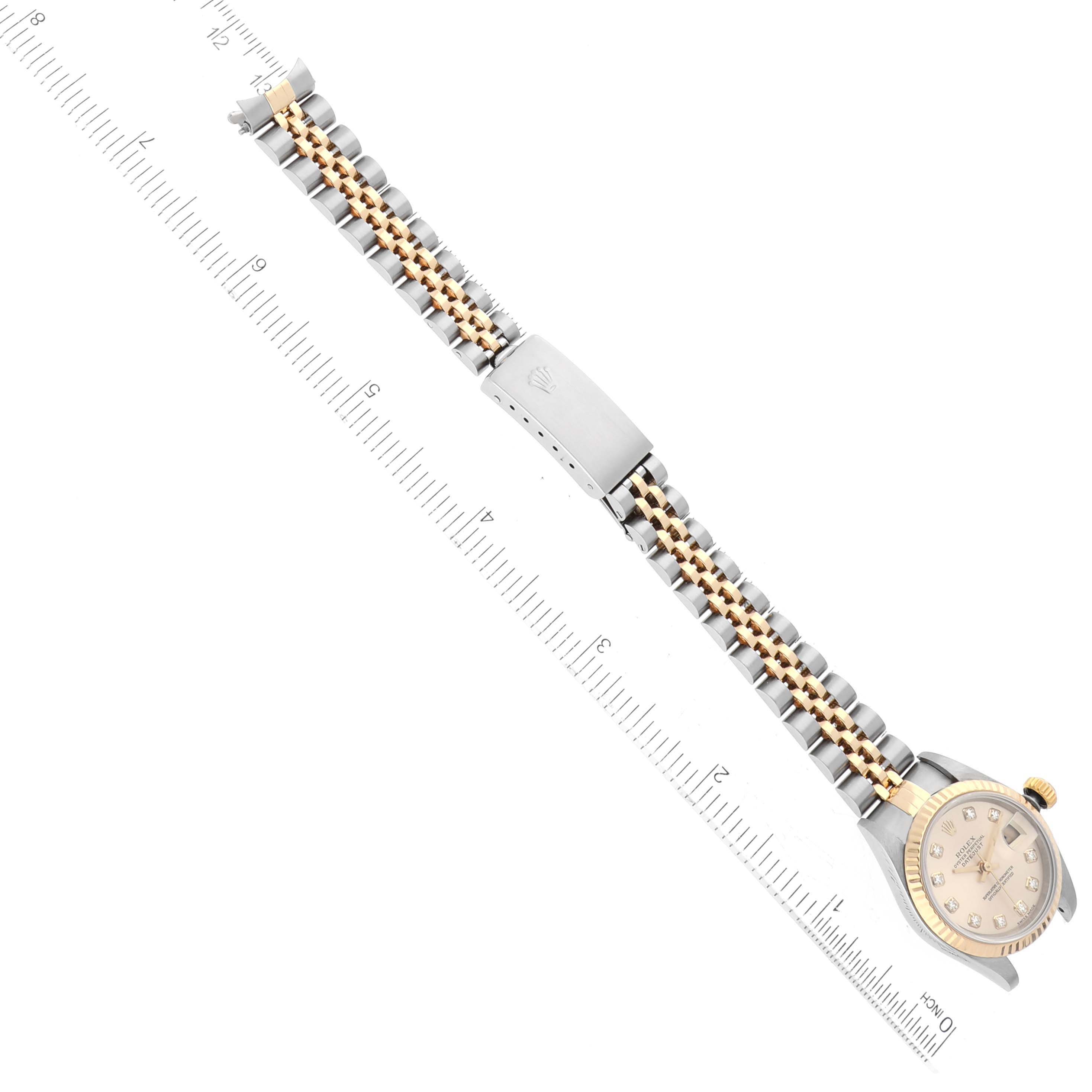 The watch, a Datejust model by Rolex, is shown from a top-down angle, displaying the face, bracelet, and clasp with a ruler for size reference.