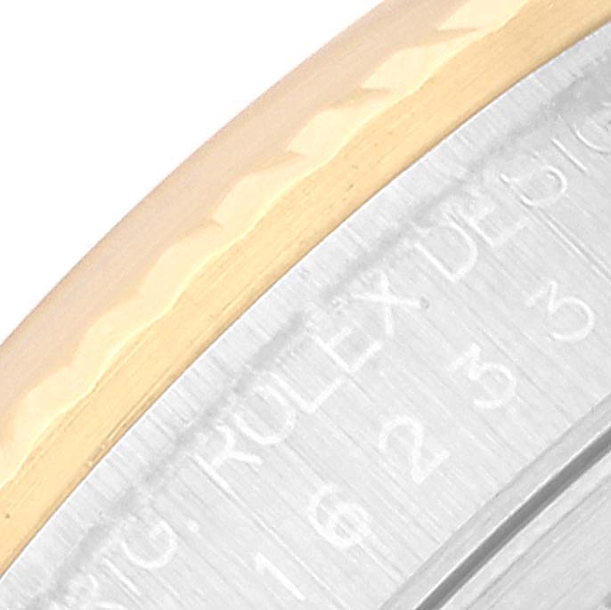 This close-up image of the Rolex Datejust 16233 Men's Steel and Gold (two tone) Champagne Dial 16233 Men's Steel and Gold (two tone) Champagne Dial watch shows a portion of the bezel and part of the engraved inner rim.