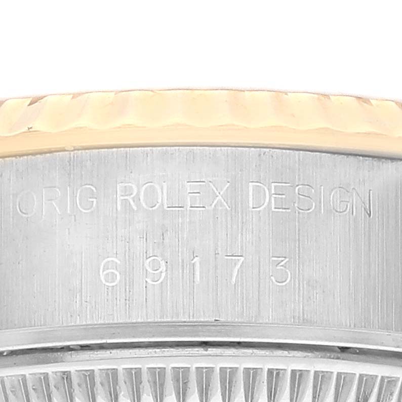 The image shows the side view of a Rolex Datejust 69173 Women's Steel and Gold (two tone) White Dial 69173 Women's Steel and Gold (two tone) White Dial watch, highlighting the bezel and engraved serial number.