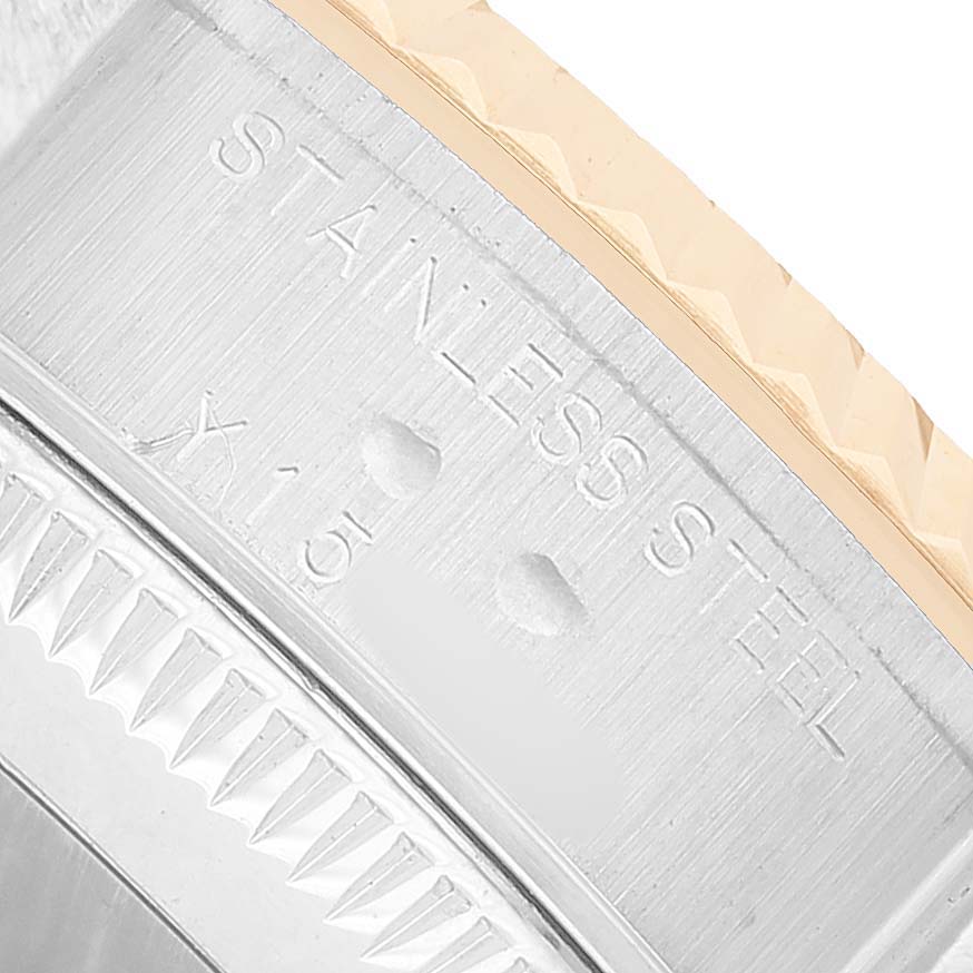 The image shows a close-up of the Rolex Datejust 79173 Women's Steel and Gold (two tone) White Dial's stainless steel bezel, focusing on its edge detailing and engraved text.