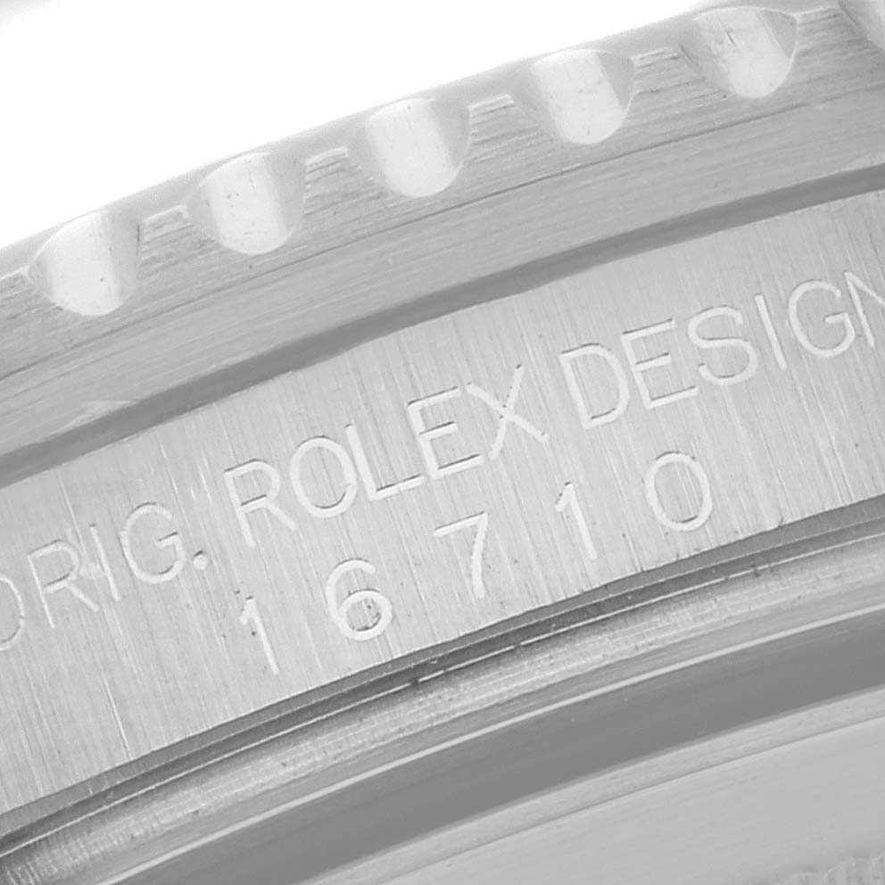 The image shows a close-up of the side of the bezel and engraved text on the case of a Rolex GMT-Master 16710 Men
s Stainless Steel Black Dial 16710 Men
s Stainless Steel Black Dial model 16710 watch.