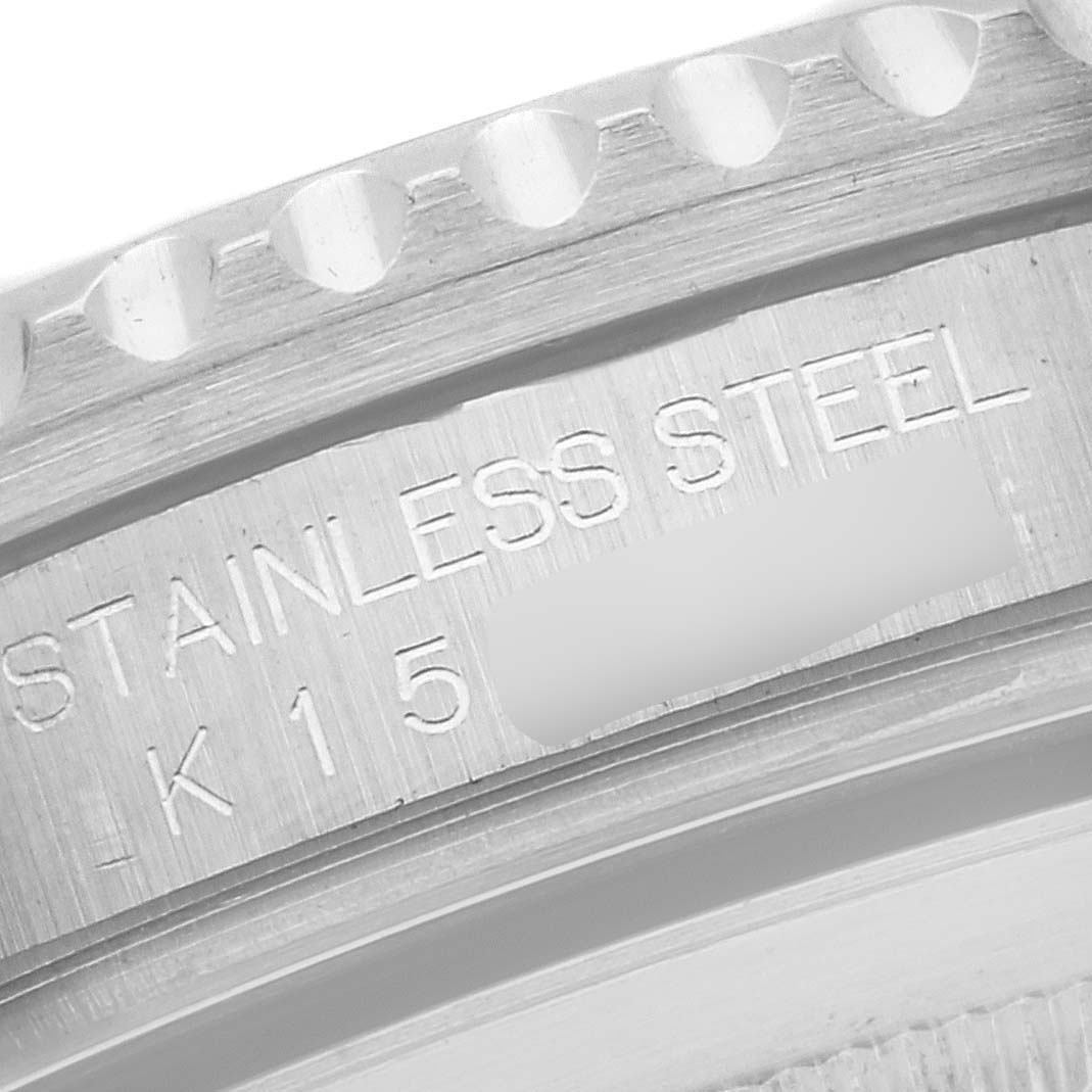 The image shows a close-up of the side of a Rolex GMT-Master 16710 Men
s Stainless Steel Black Dial 16710 Men
s Stainless Steel Black Dial watch, focusing on its stainless steel casing with some text engraved.