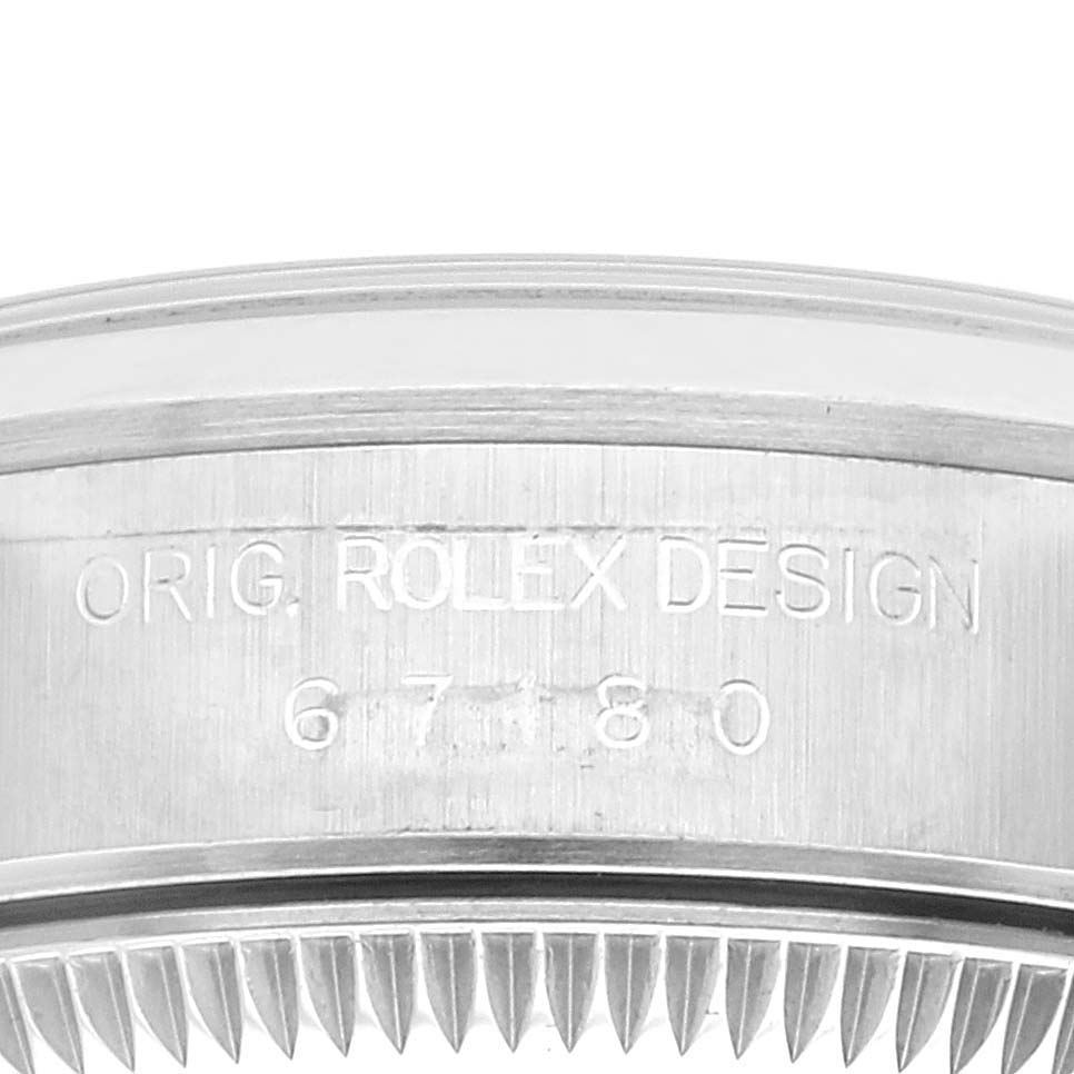 This close-up image shows the side of the bezel of a Rolex Oyster Perpetual 67180 Women
s Stainless Steel Pink Dial 67180 Women
s Stainless Steel Pink Dial watch, highlighting the engraving.