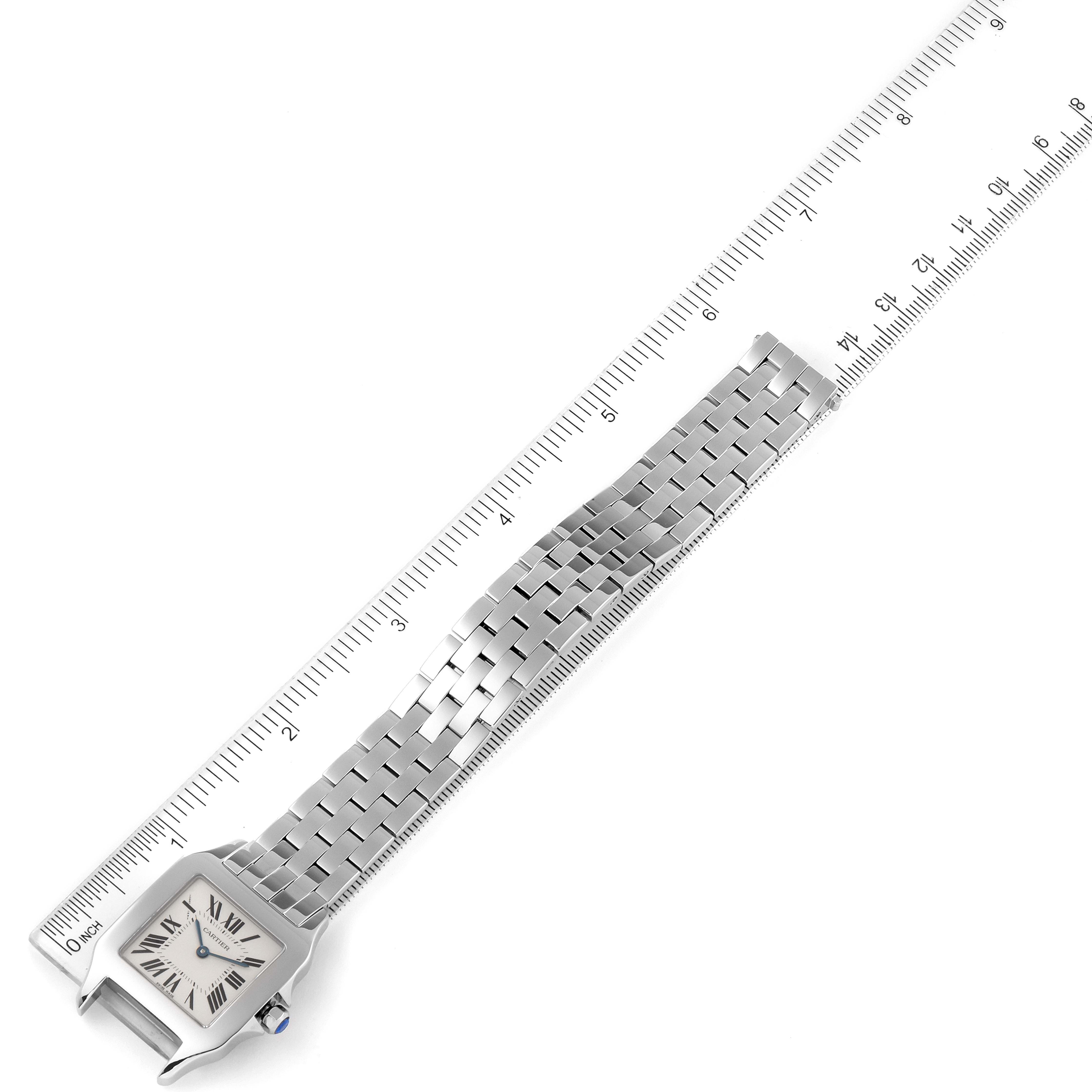 The image shows a top view of the Cartier Santos Demoiselle W25065Z5 Women
s Stainless Steel Silver Dial W25065Z5 Women
s Stainless Steel Silver Dial watch, displaying the watch face, bracelet, and a ruler for measurement.