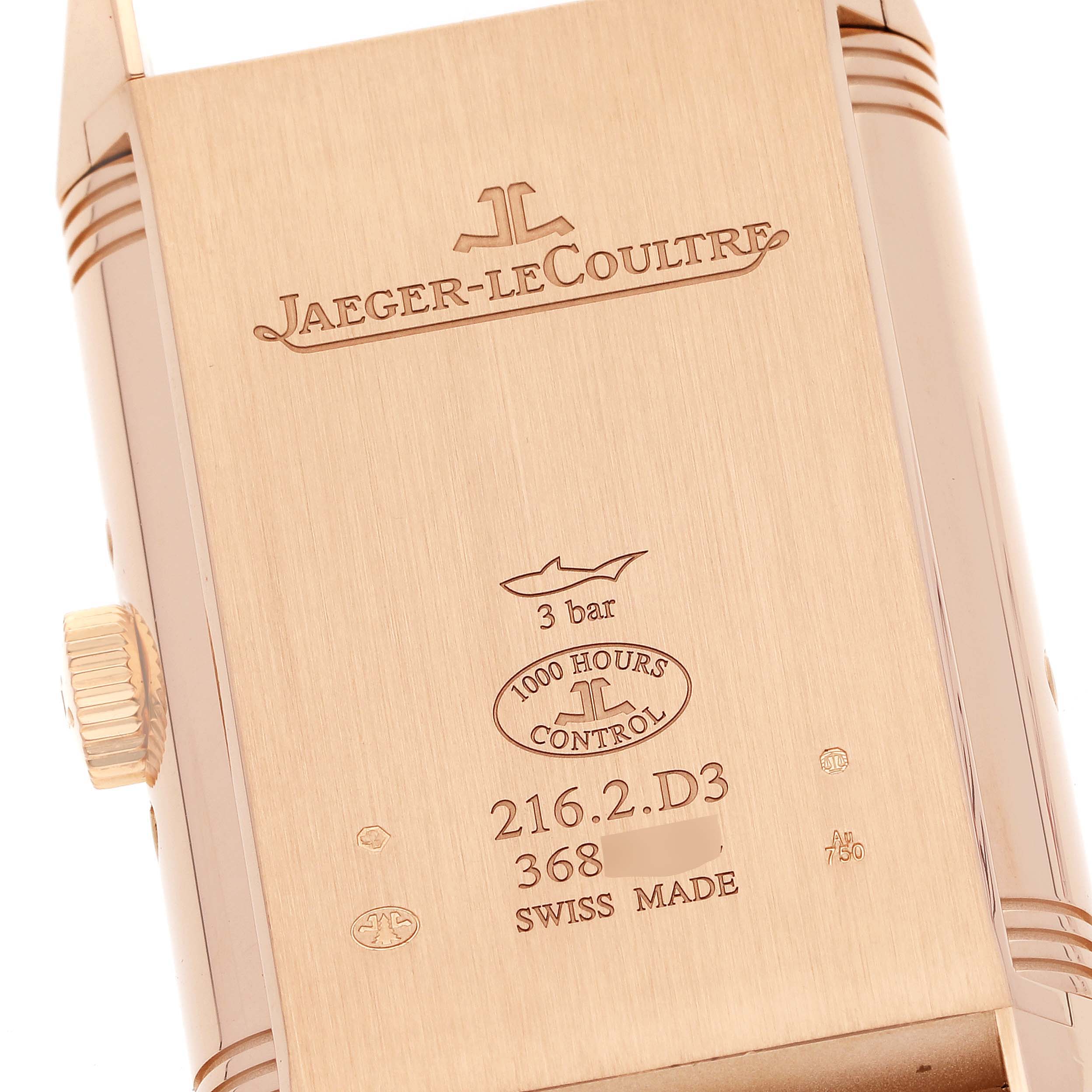 The image shows the back side and crown of a Jaeger-LeCoultre Reverso watch, highlighting the brand and model engravings.