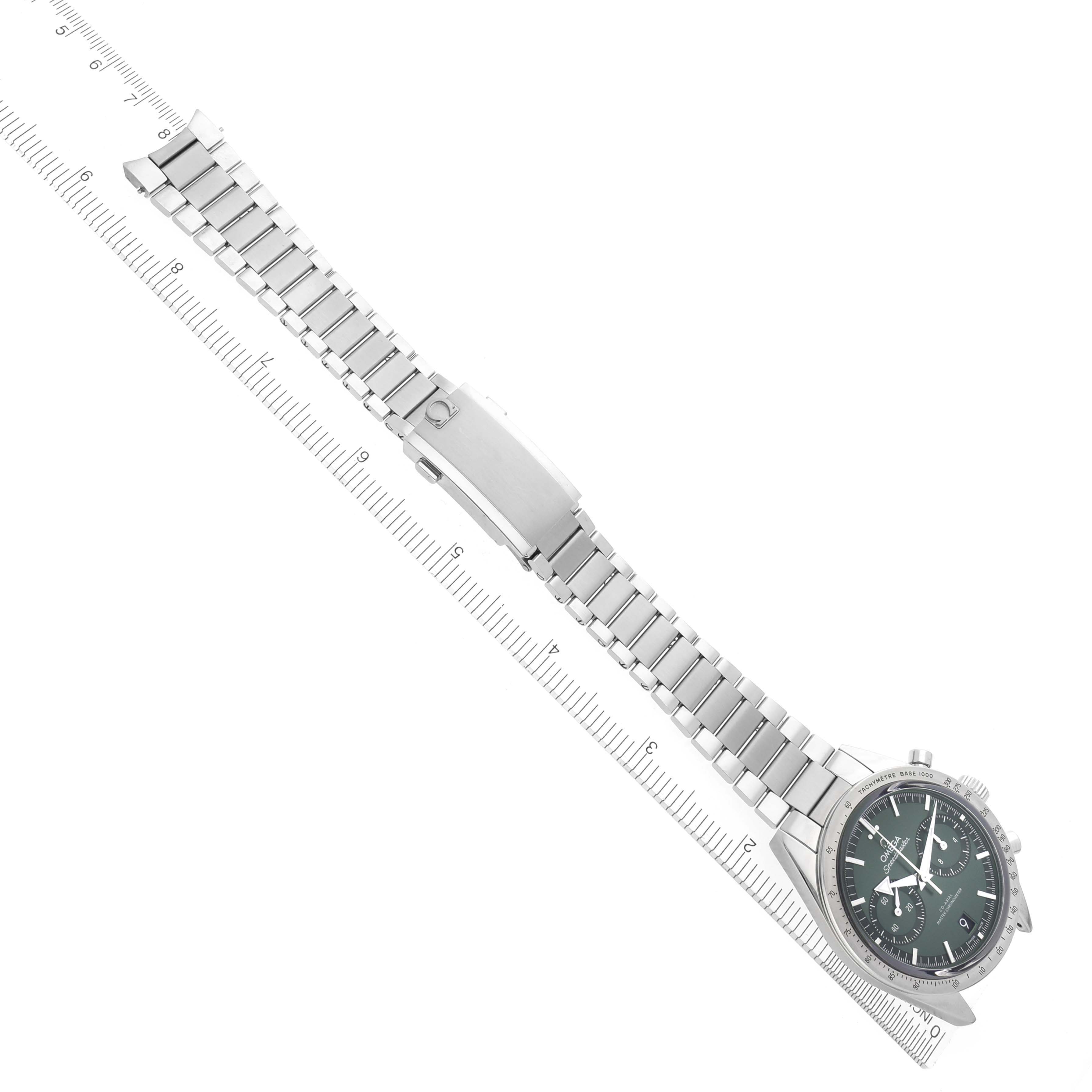 The Omega Speedmaster 332.10.41.51.01.001 Men's Stainless Steel Green Dial 332.10.41.51.01.001 Men's Stainless Steel Green Dial watch is displayed at an angled view, showing the full bracelet and clasp, alongside a measuring ruler.