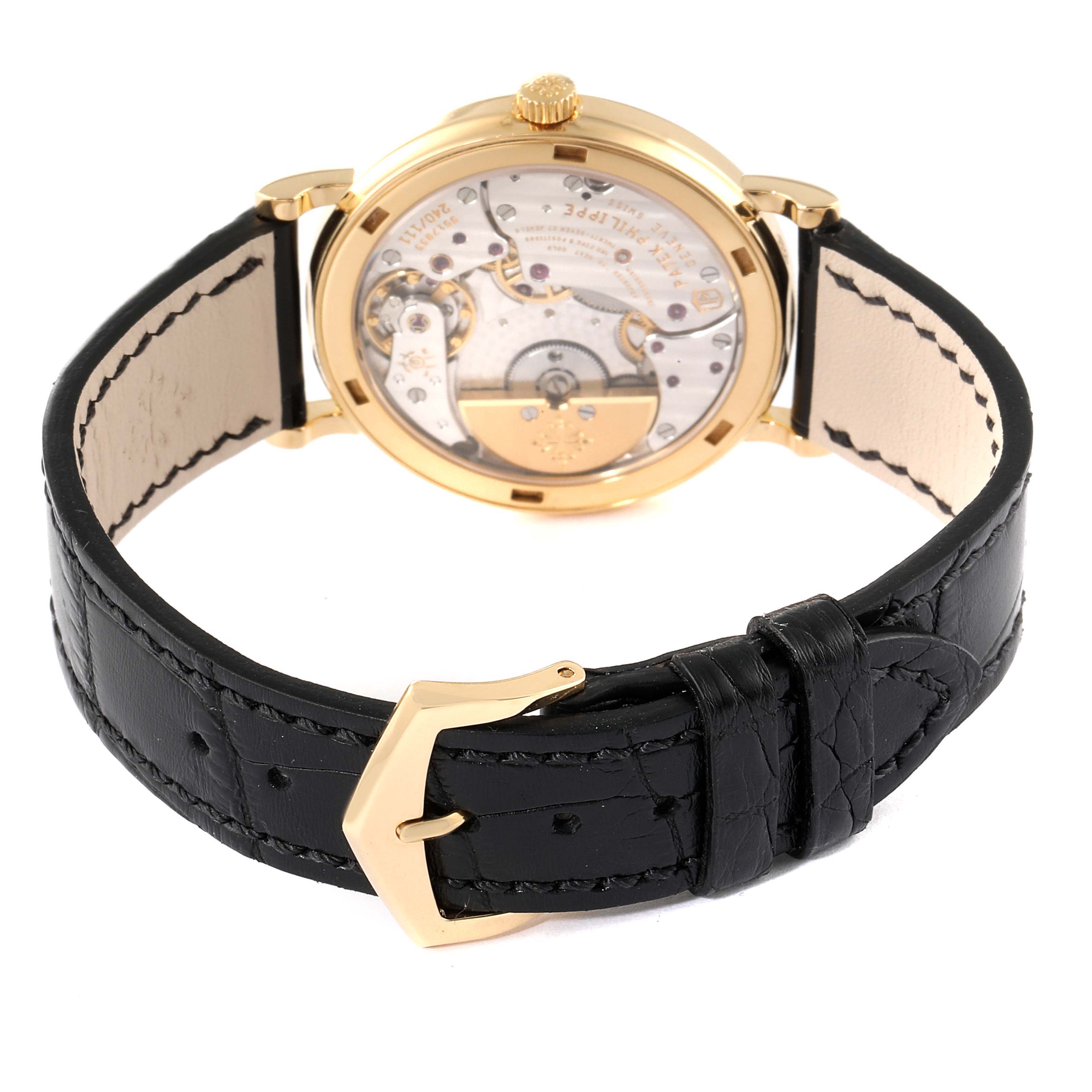 The image shows the back view of a Patek Philippe Calatrava 5120J Men's Yellow Gold White Dial 5120J Men's Yellow Gold White Dial watch, highlighting its movement and black leather strap with a gold buckle.