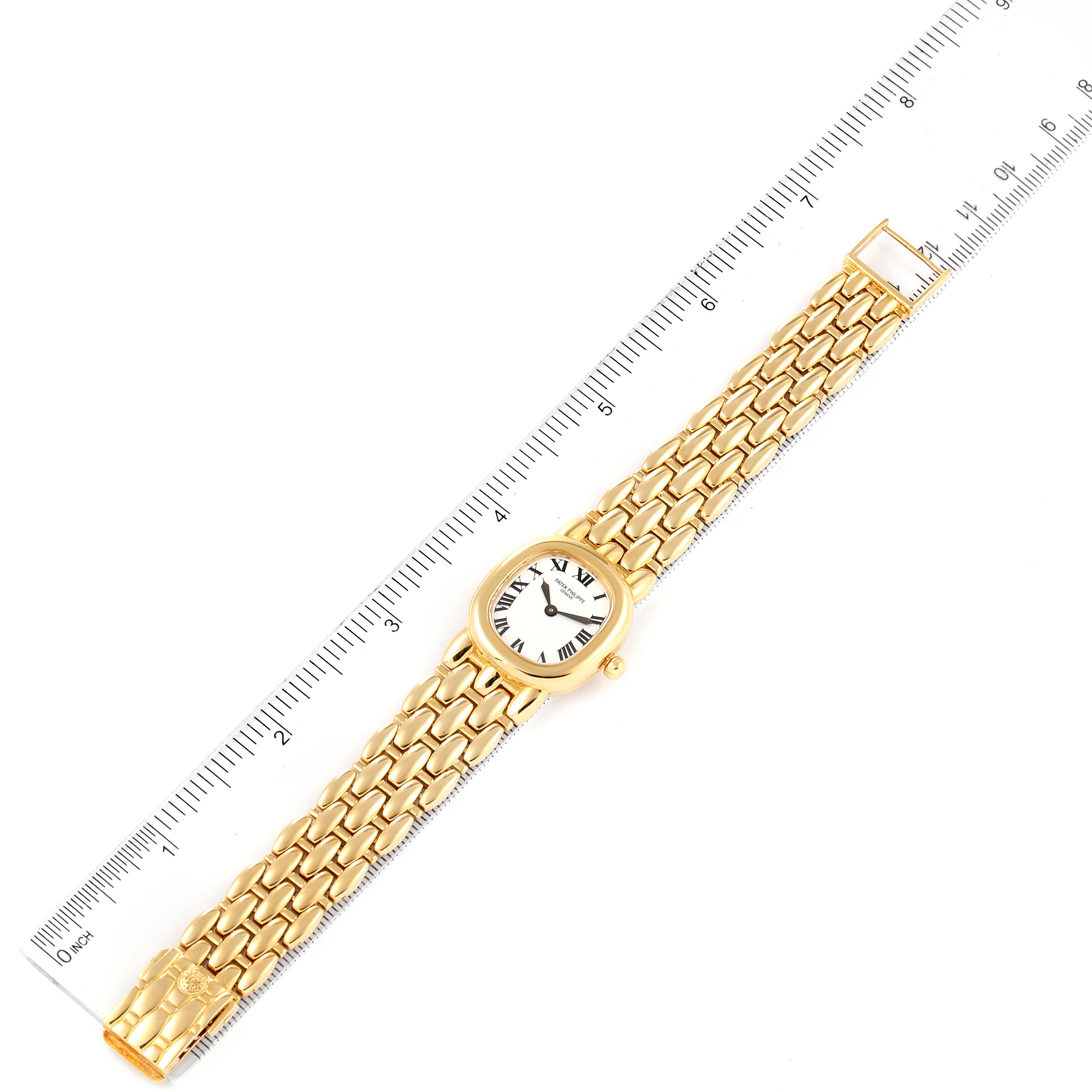 The image shows the Patek Philippe Golden Ellipse 4830J Women's Yellow Gold White Dial 4830J Women's Yellow Gold White Dial watch laid flat with a ruler beside it for scale.
