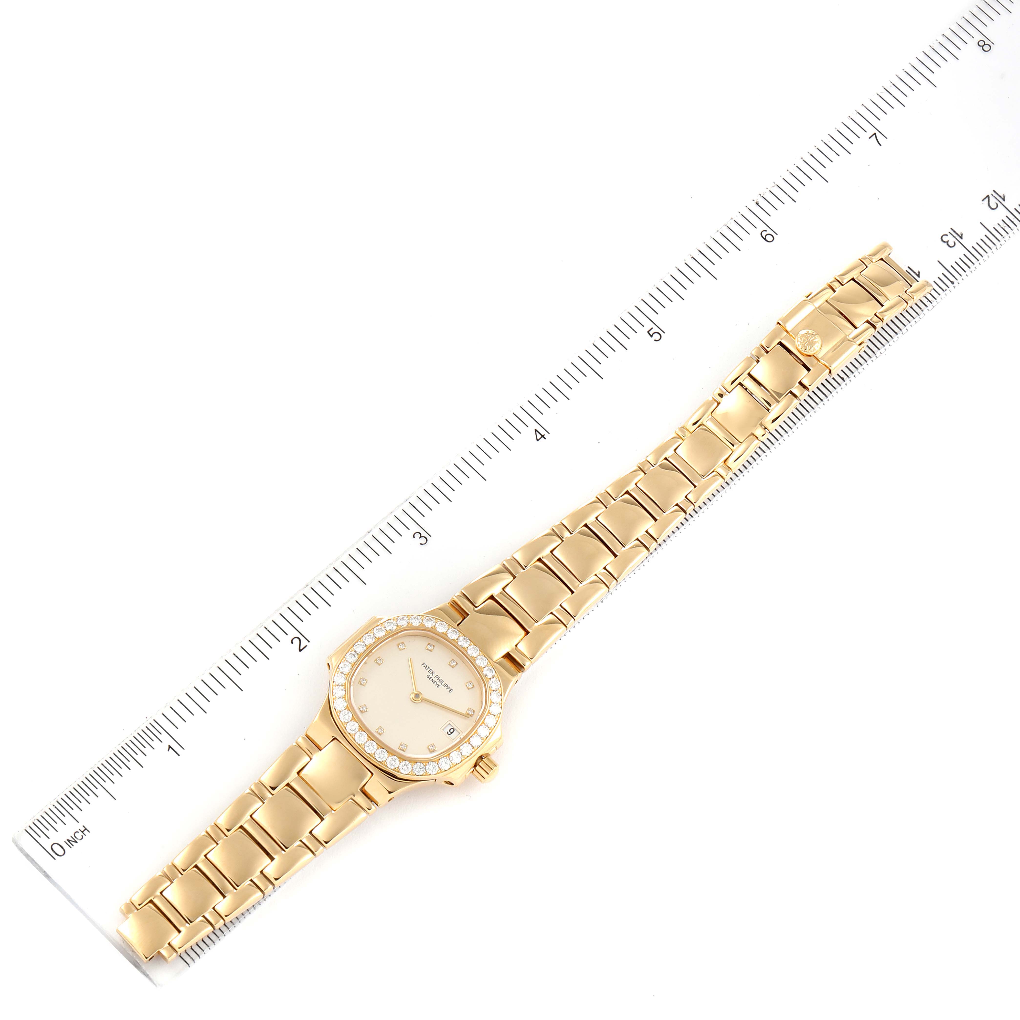 This image shows a top-down angle of a Patek Philippe Nautilus 4700/530 Women's Yellow Gold Beige Dial 4700/530 Women's Yellow Gold Beige Dial watch against a ruler for scale.