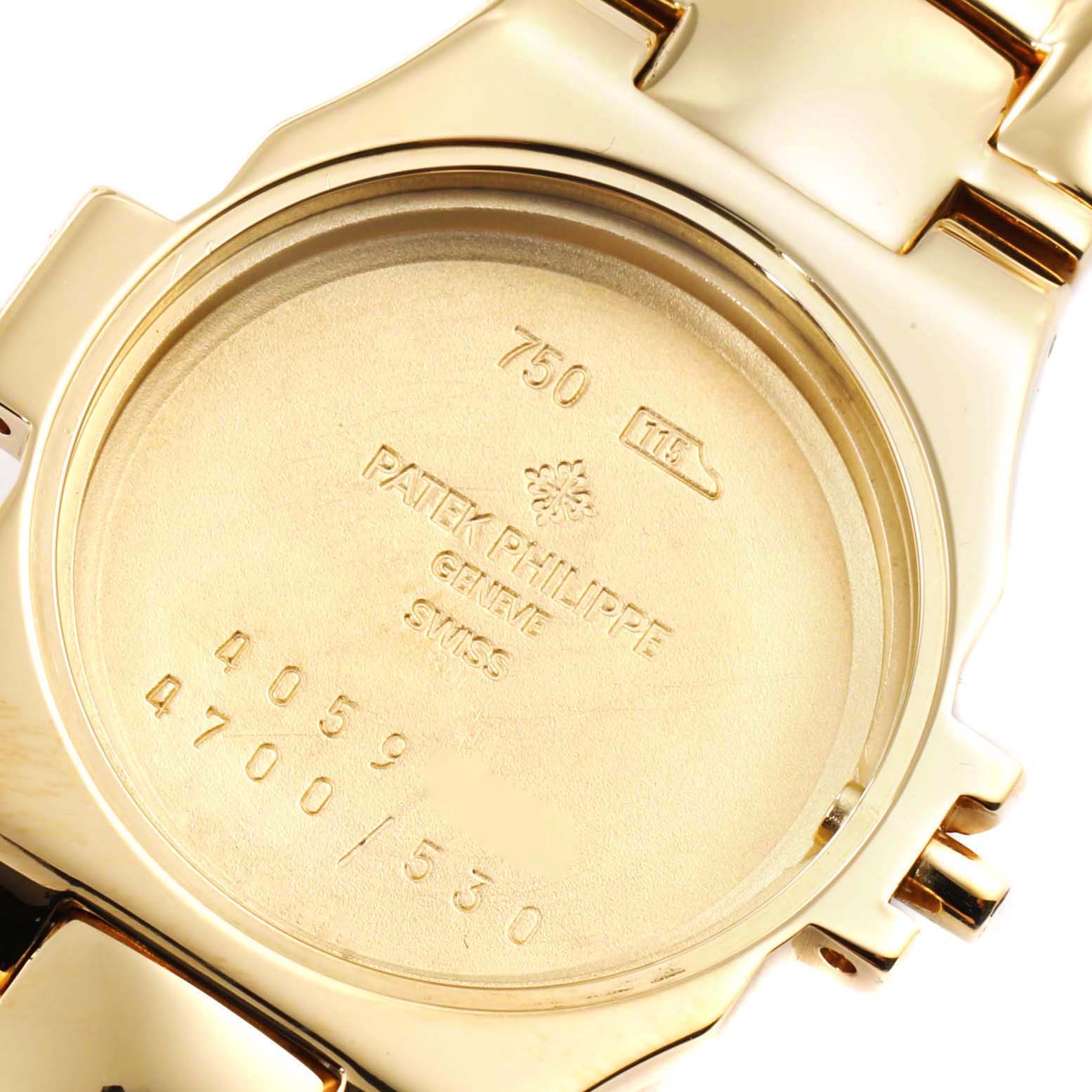 The image shows the case back of a Patek Philippe Nautilus 4700/530 Women's Yellow Gold Beige Dial 4700/530 Women's Yellow Gold Beige Dial watch, highlighting model engravings and precious metal markings.