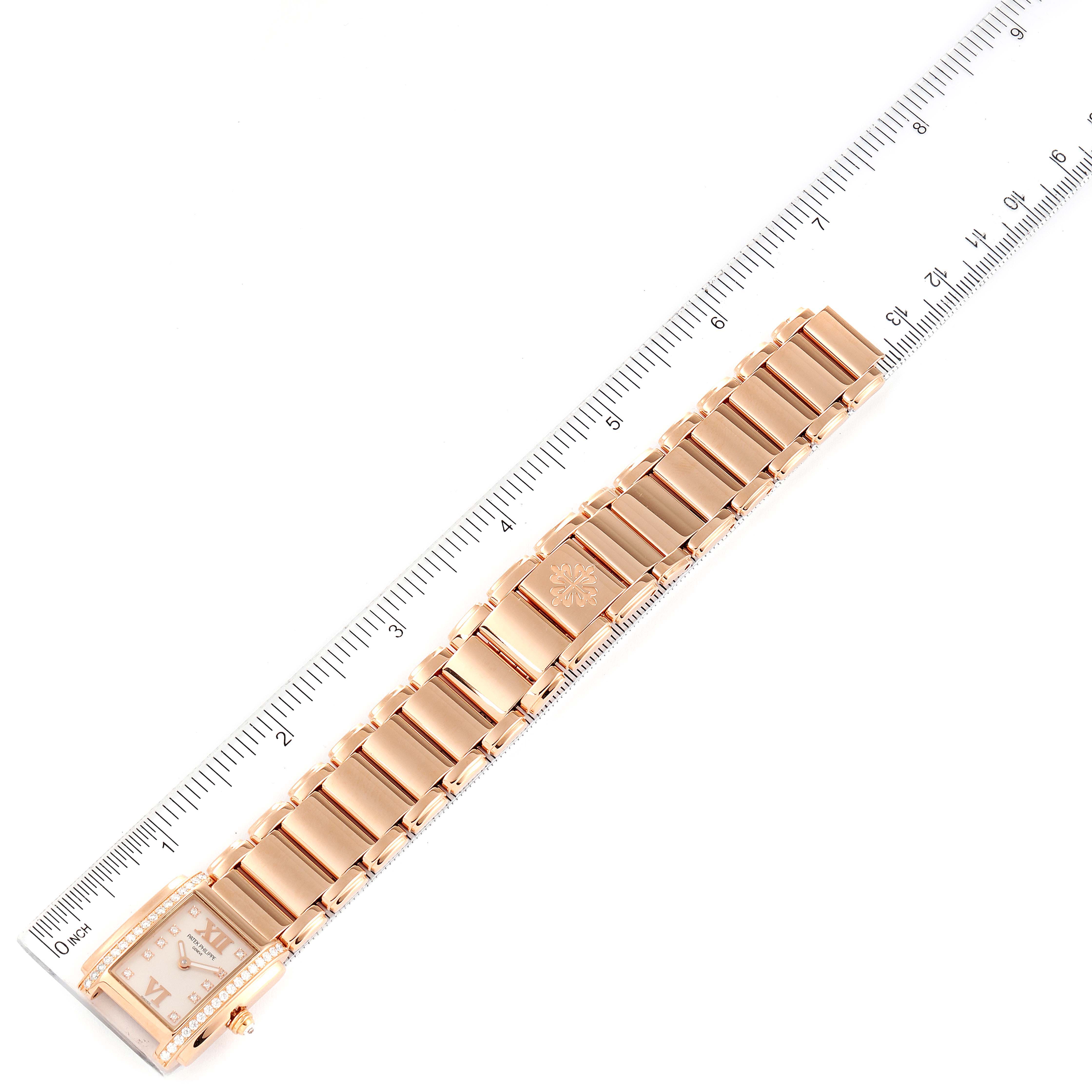 The image shows the Patek Philippe Twenty-4 4908R Women's Rose Gold Silver Dial 4908R Women's Rose Gold Silver Dial model from a top view, highlighting its bracelet and case near a ruler for scale.