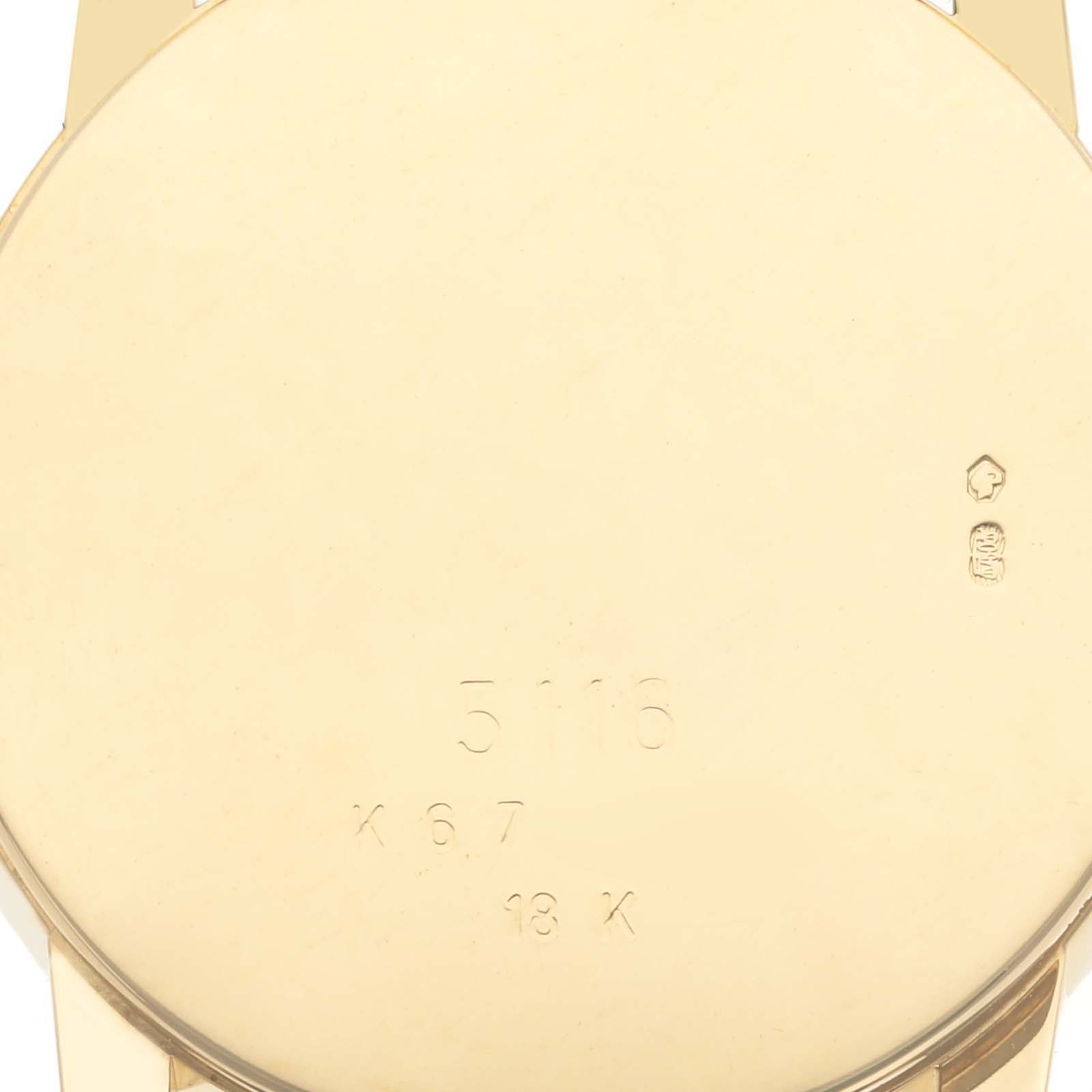 The image shows the back of a Rolex Cellini 5116/8 Men
s Yellow Gold Champagne Dial 5116/8 Men
s Yellow Gold Champagne Dial watch case, highlighting its inscriptions and gold finish.