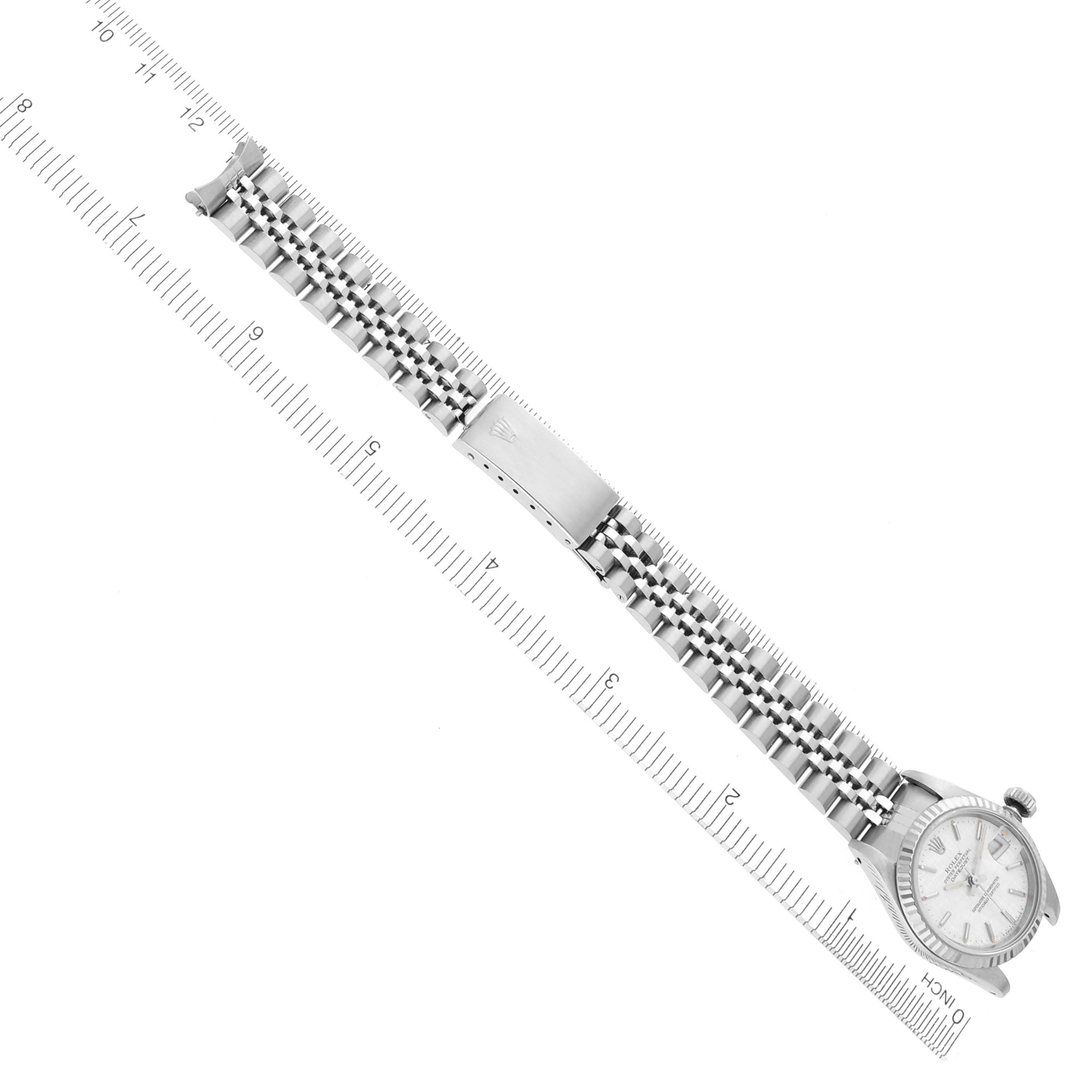The image shows a side angle of a Rolex Datejust 69174 Women's Stainless Steel Silver Dial 69174 Women's Stainless Steel Silver Dial watch with an extended jubilee bracelet, alongside a ruler for scale.