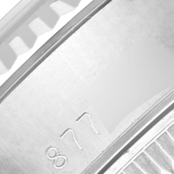 The image shows a close-up of the side of a Rolex Datejust 69174 Women's Stainless Steel Silver Dial 69174 Women's Stainless Steel Silver Dial, highlighting the bezel and part of the serial number.